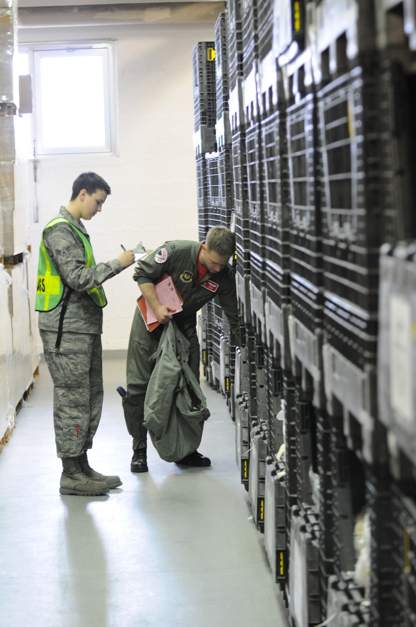 SPANGDAHLEM AIR BASE, Germany - Airman 1st Class Brooke Wilson, 52nd Logistics Readiness Squadron mobility apprentice, issues Capt. Benjamin Meier, 480th Fighter Squadron fighter pilot, his chemical gear here March 18 during a personnel deployment function in support of Operation Odyssey Dawn March 18. Joint Task Force Odyssey Dawn is the U.S. Africa Command task force established to provide operational and tactical command and control of U.S. military forces supporting the international response to the unrest in Libya and enforcement of United Nations Security Council Resolution (UNSCR) 1973. UNSCR 1973 authorizes all necessary measures to protect civilians in Libya under threat of attack by Qadhafi regime forces.  JTF Odyssey Dawn is commanded by U.S. Navy Admiral Samuel J. Locklear, III. (U.S. Air Force photo/Senior Airman Nick Wilson)