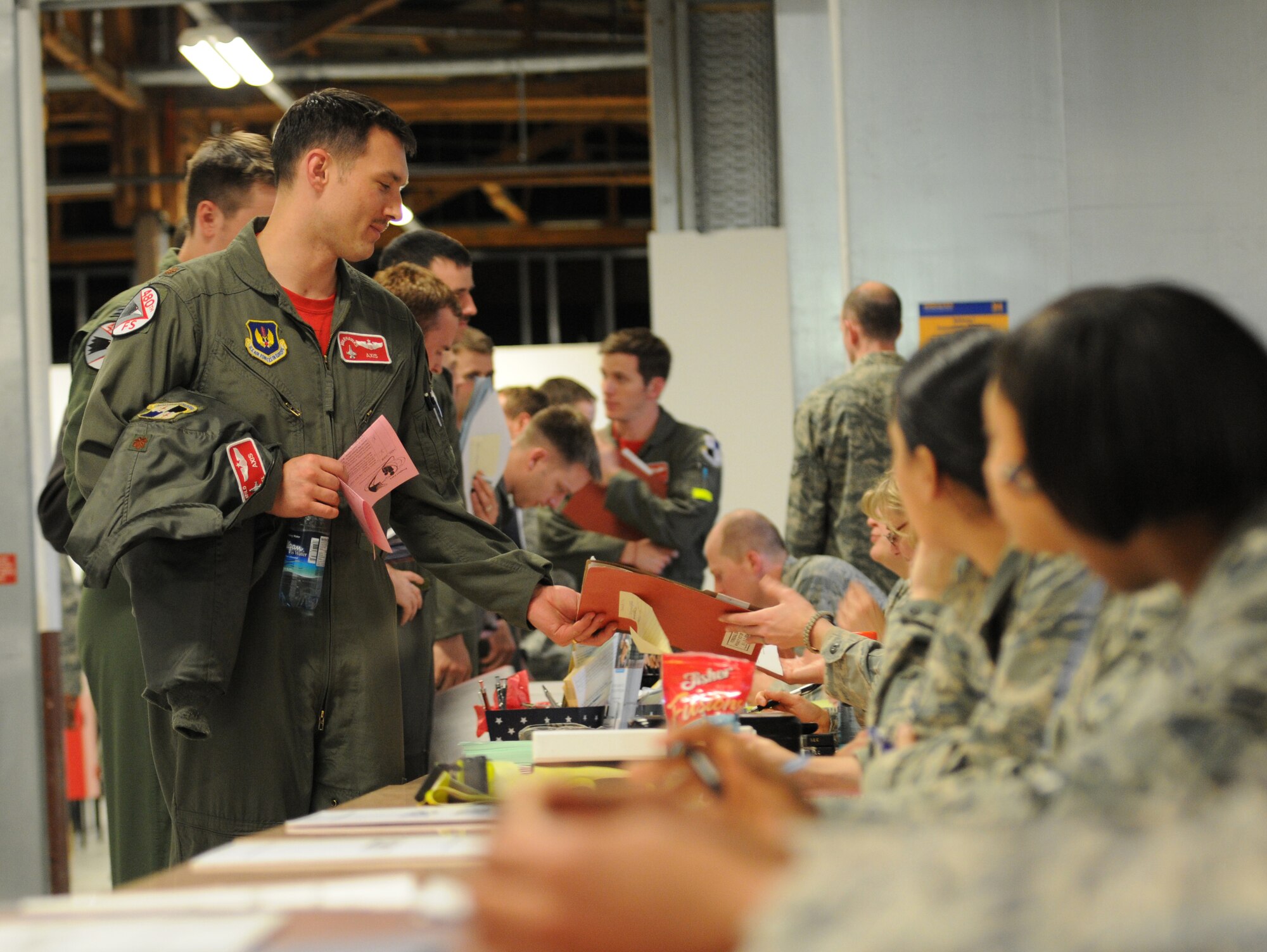 SPANGDAHLEM AIR BASE, Germany -- Pilots from the 480th Fighter Squadron process through the personnel deployment function line here prior to deploying in support of Operation Odyssey Dawn March 18. Joint Task Force Odyssey Dawn is the U.S. Africa Command task force established to provide operational and tactical command and control of U.S. military forces supporting the international response to the unrest in Libya and enforcement of United Nations Security Council Resolution (UNSCR) 1973. UNSCR 1973 authorizes all necessary measures to protect civilians in Libya under threat of attack by Qadhafi regime forces.  JTF Odyssey Dawn is commanded by U.S. Navy Admiral Samuel J. Locklear, III. (U.S. Air Force photo/Senior Airman Nick Wilson)