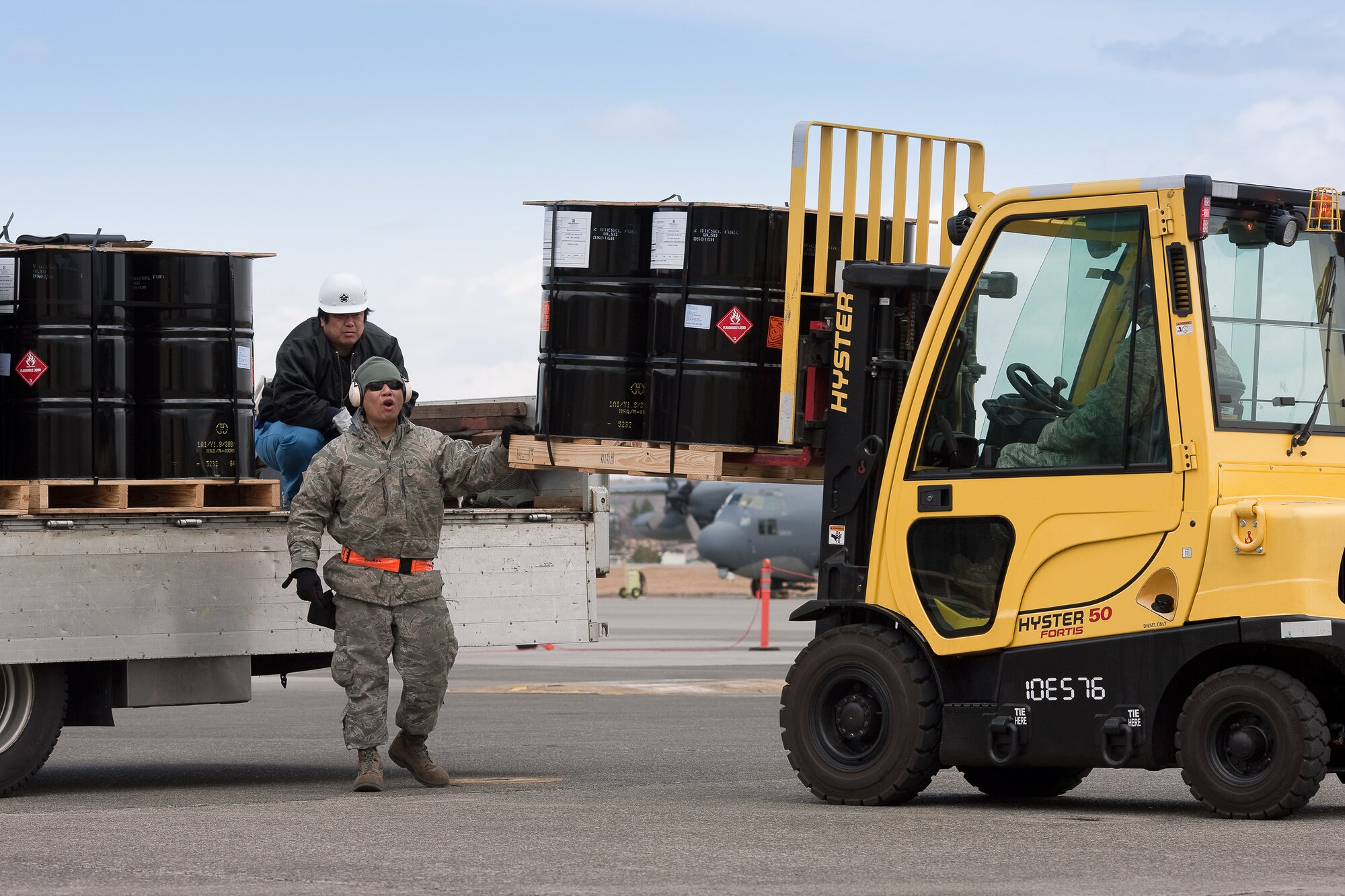 YOKOTA AIR BASE, Japan -- Senior Airman Stanley Quach, 374th Logistics Readiness Squadron, marshals a forklift while loading a pallet at Yokota Air Base, March 23. The 374th LRS prepared the fuel for shipment to the Caterpillar factory in Sagamihara. The plant, which employees thousands and manufactures equipment critical to the rebuilding of Japan, currently runs on generator power. (U.S. Air Force photo/Osakabe Yasuo)