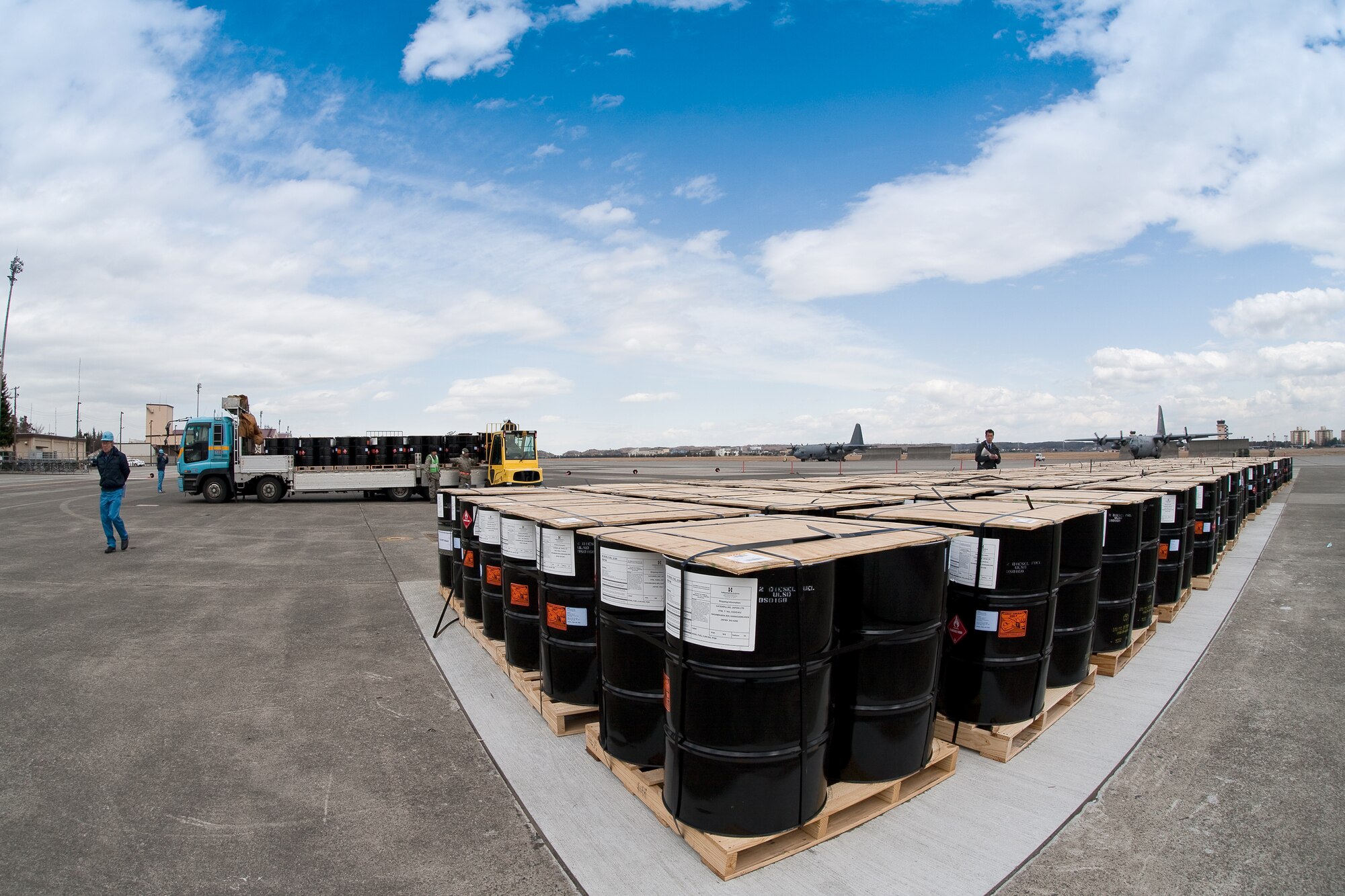 YOKOTA AIR BASE, Japan -- Members from the 374th Logistics Readiness Squadron load pallets of diesel fuel onto Japanese truck at Yokota Air Base March 23. The 374th LRS prepared the fuel for shipment to the Caterpillar factory in Sagamihara. The plant, which employees thousands and manufactures equipment critical to the rebuilding of Japan, currently runs on generator power. (U.S. Air Force photo/Osakabe Yasuo)