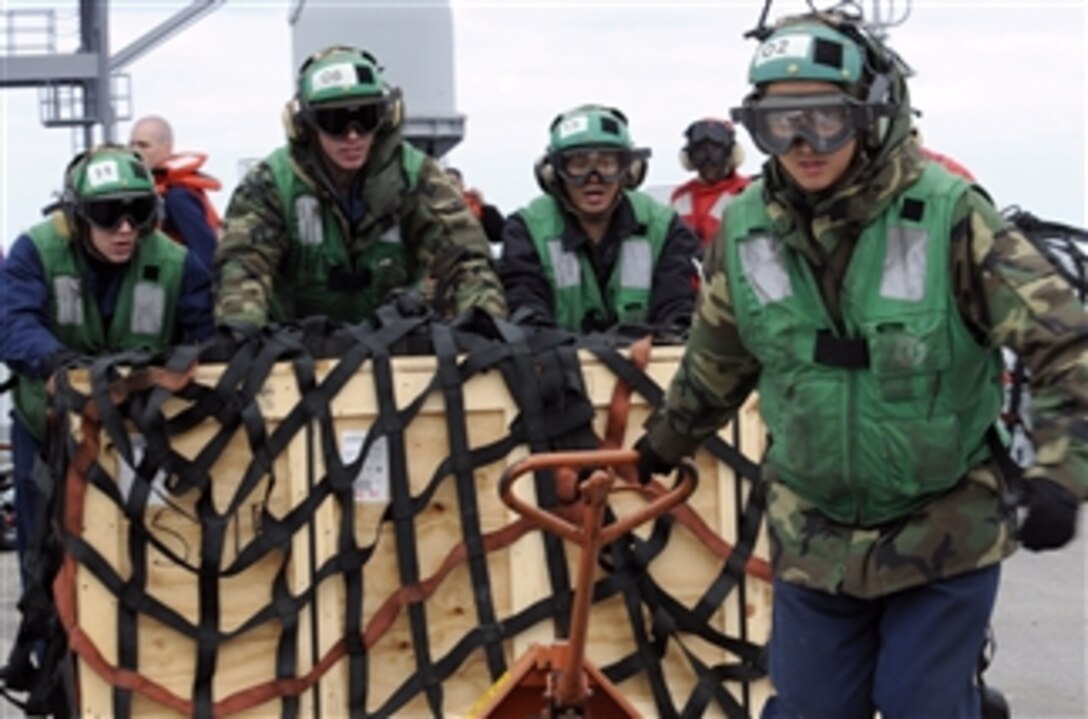 Petty Officer 2nd Class Shizhen Huang (right), assigned to Light Helicopter Anti-Submarine Squadron 51, pulls a pallet of supplies to the flight deck of the U.S. 7th Fleet command ship USS Blue Ridge (LCC 19) in the South China Sea on March 21, 2011.  The Blue Ridge transferred pallets of humanitarian assistance supplies to the Military Sealift Command fleet replenishment oiler USNS Pecos (T-AO 197) to support Operation Tomodachi relief efforts in Japan.  
