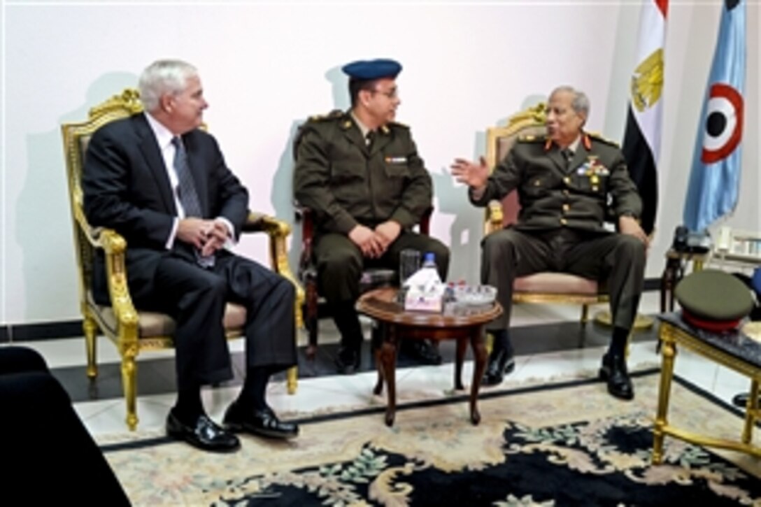 U.S. Defense Secretary Robert M. Gates meets briefly with Egyptian Maj. Gen. Hassan el Rouni, right, at the Cairo International Airport, Egypt, March 23, 2011.