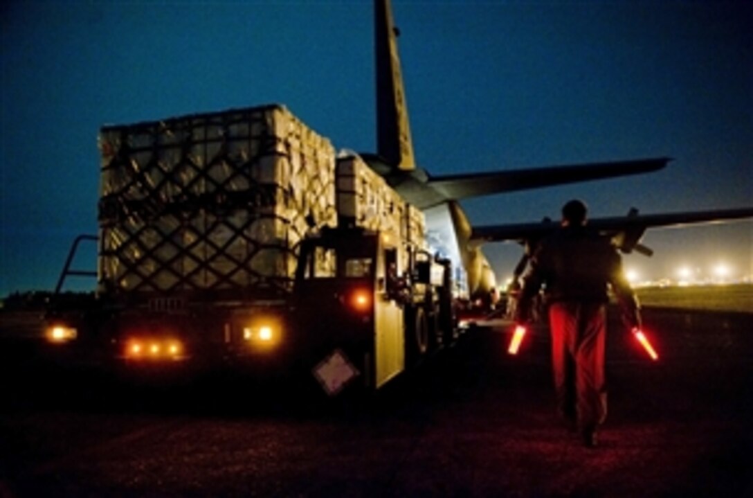 Senior Airman Jason Barbieri guides a K-loader full of blankets into a C-130H Hercules at Yakota Air Base, Japan, on March 18, 2011.  Airmen from the 36th Airlift Squadron provided blankets to Sendai Airport in support of Japan's earthquake and tsunami relief efforts.  