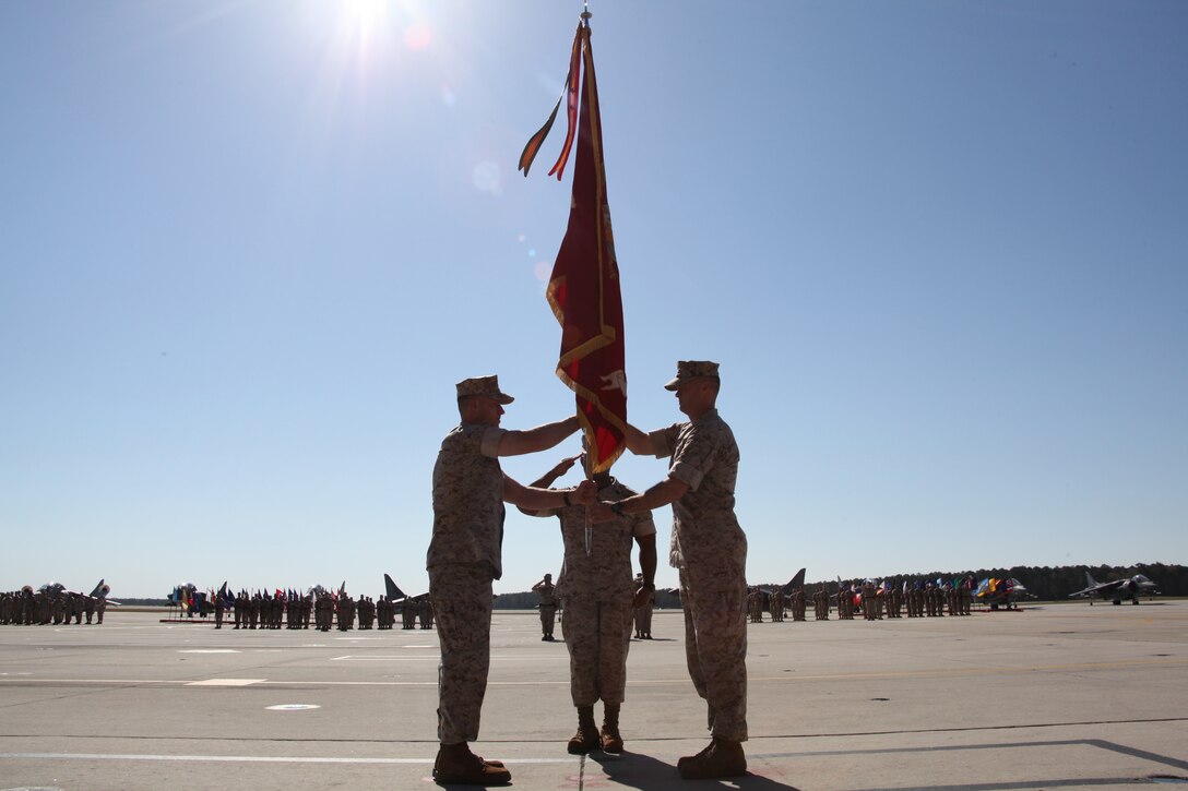 Sgt. Maj. Steven Collier, center, salutes as Lt. Col. John A. Rahe Jr., right, passes the Marine Attack Training Squadron 203 colors to Lt. Col. Craig C. Wirth during the VMAT-203 change of command ceremony at the squadron hangar March 24.
