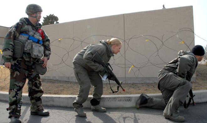 KUNSAN AIR BASE, Republic of Korea -- Master Sgt. Myong Yi, 8th Security Forces Squadron NCO in charge of standardization and evaluation and 8th SFS exercise evaluation team lead, observes as opposition forces members attack a security forces command post during an exercise. As an 8th SFS EET member, Sergeant Yi evaluates squadron members in how they would respond if the scenario were a real-world situation. (U.S. Army photo/Specialist Christopher Wellner)