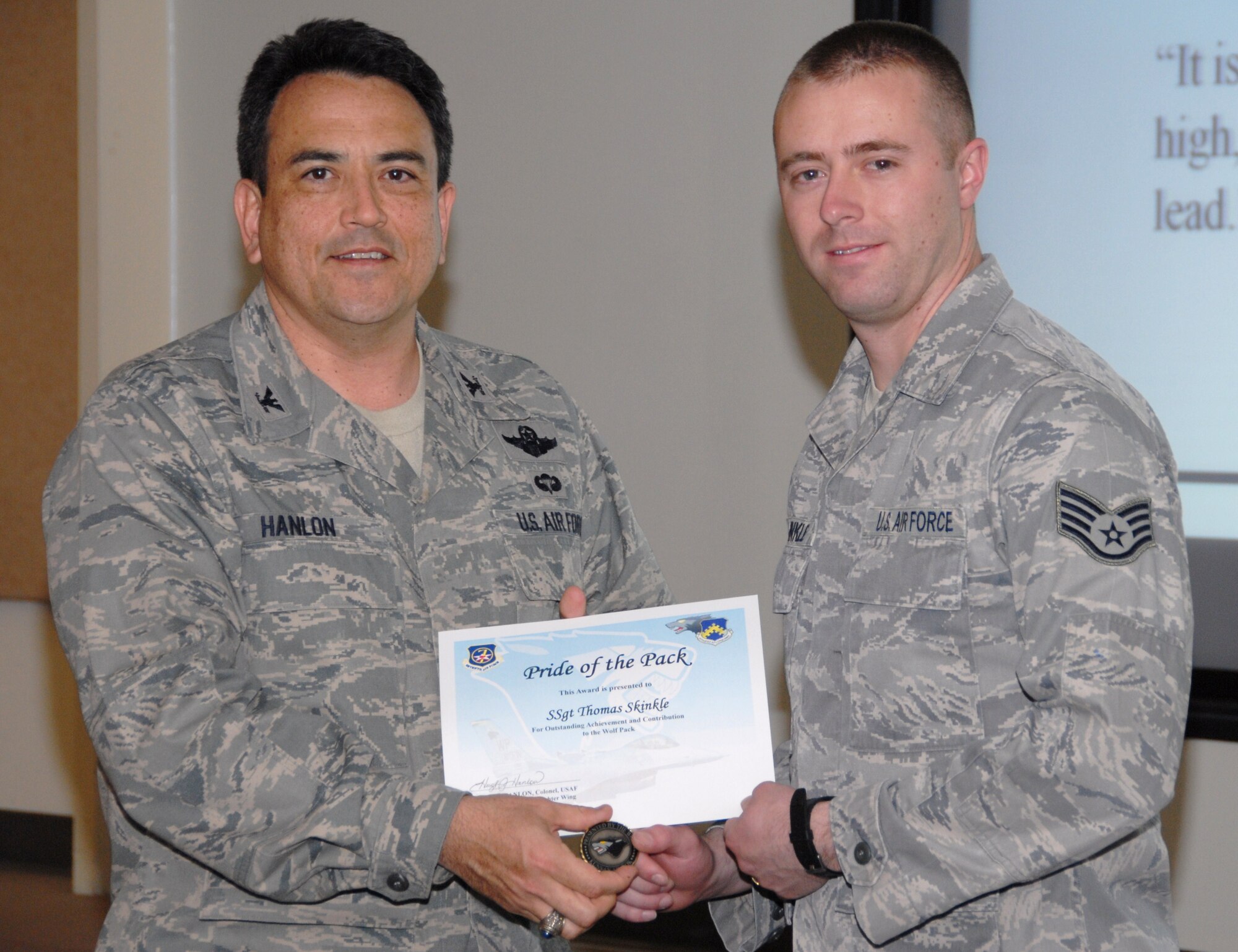 KUNSAN AIR BASE, Republic of Korea -- Col. Hugh Hanlon, 8th Fighter Wing vice commander, presents Staff Sgt. Thomas Skinkle, 8th Fighter Wing public affairs NCO in charge of video, with a Pride of the Pack award here March 24. (U.S. Air Force photo/Capt. Sheryll Klinkel)
