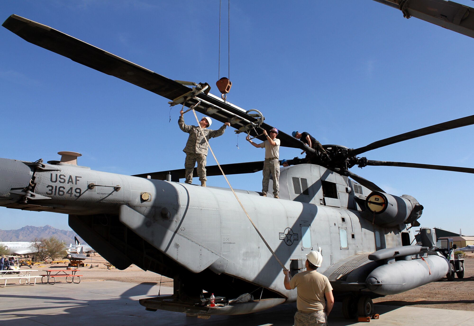 TUCSON, Ariz. – Members from the 923rd Aircraft Maintenance Squadron, 55th Helicopter Maintenance Unit attach the final rotor blade to the MH-53 Jolly Green on March 4. The crew chiefs and maintainers from the 55th HMU helped reassemble the aircraft to be put on display at the Pima Air and Space Museum. (U.S. Air Force photo/Staff Sgt. Kevin Roth)