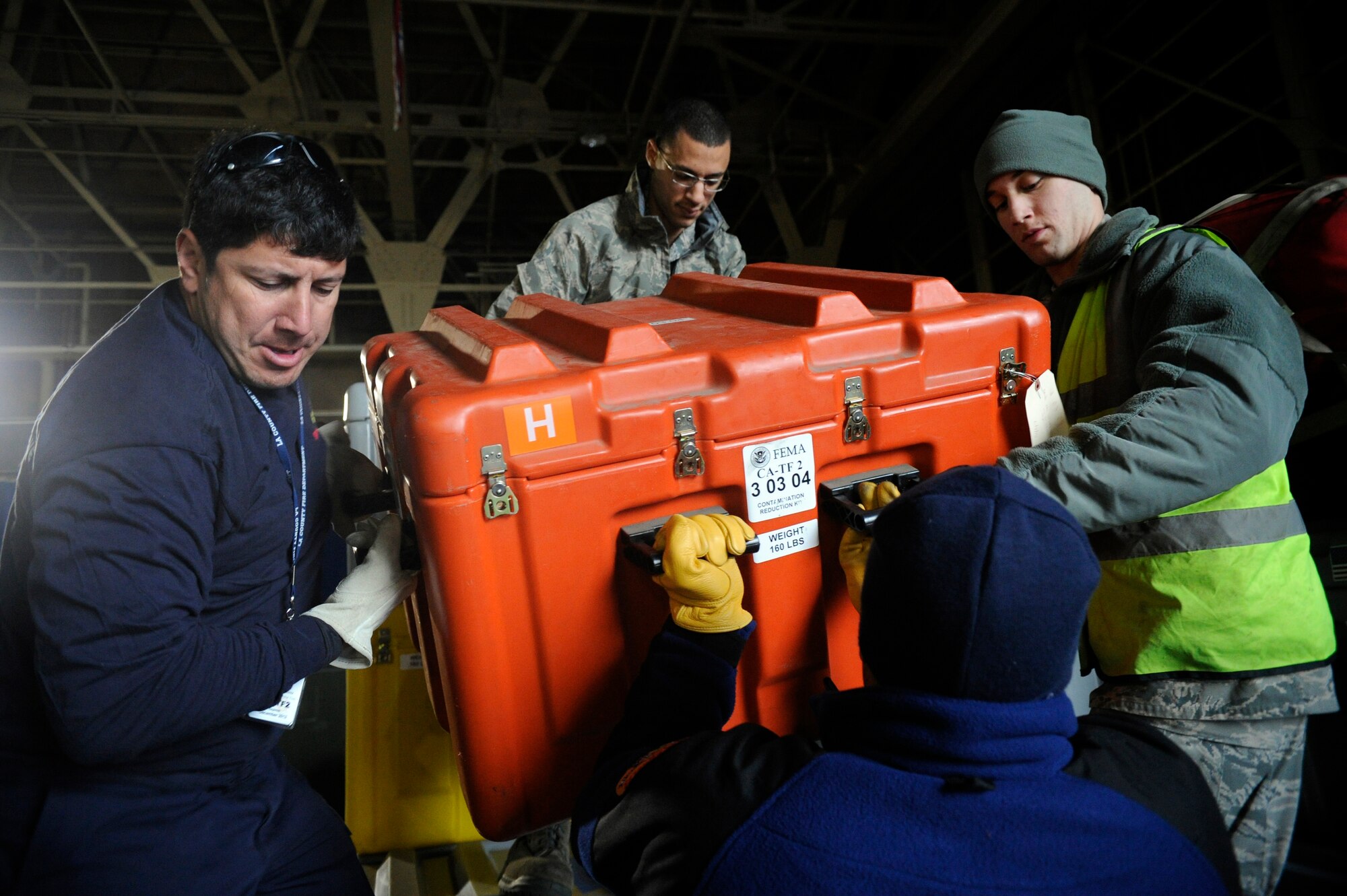 U.S. Air Force Airmen help members of LA-TF2 move a case while loading their pallet at Misowa Air Base, Japan, March 14, 2011. Members of the Los Angeles, Calif. and Fairfax, Va., Search and Rescue Team, Task Force 2 and 1, respectively are responding to the recent national emergency in Japan due to the earthquake while providing needed care, rescue techniques and tools.(U.S. Air Force photo/ Tech. Sgt. Daniel St. Pierre)