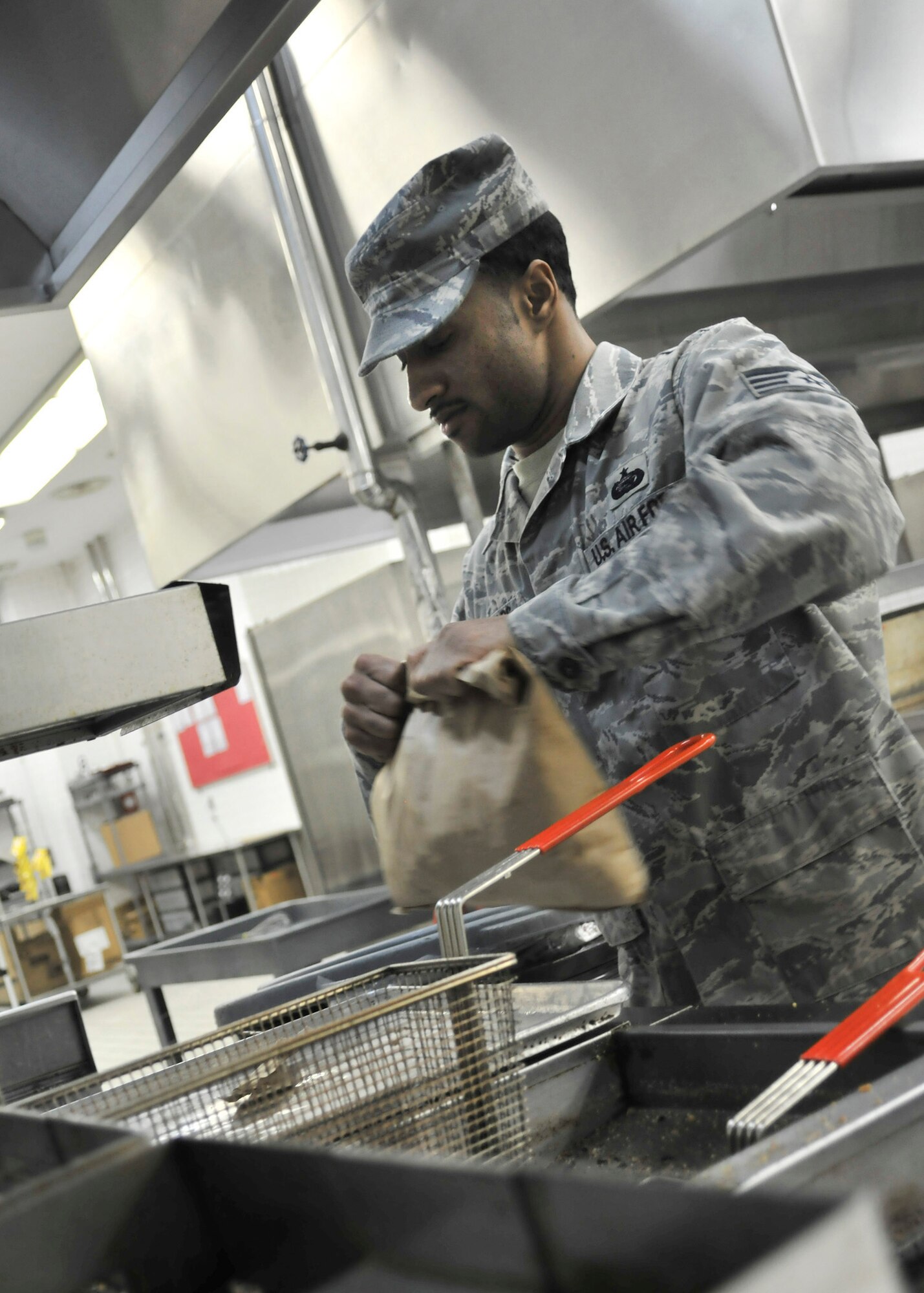 YOKOTA AIR BASE, Japan -- Staff Sgt. Justin Reynolds, 374th Force Support Squadron dining facility shift leader, prepares to cook a batch of fries here March 24. The Dayton, Ohio native is working modified hours in order to provide meals to all authorized Yokota and TDY members assisting with Operation Tomodachi. (U.S. Air Force photo/Airman 1st Class Andrea Salazar)