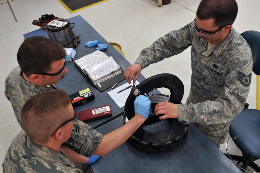 WHITEMAN AIR FORCE BASE, Mo. -- Staff Sgt. David Hall (right), Airman 1st Class Scott Whitney (top left) and Airman 1st Class Travis Dowler (bottom left), 509th Maintenance Squadron hydraulic systems repair technicians, measure a heat stack of a B-2 Spirit brake system March 22, 2011. Sergeant Hall instructed Airman Whitney and Airman Dowler on proper repair procedures for the B-2's brake system. (U.S. Air Force photo by Tech. Sgt. Charles Larkin Sr)