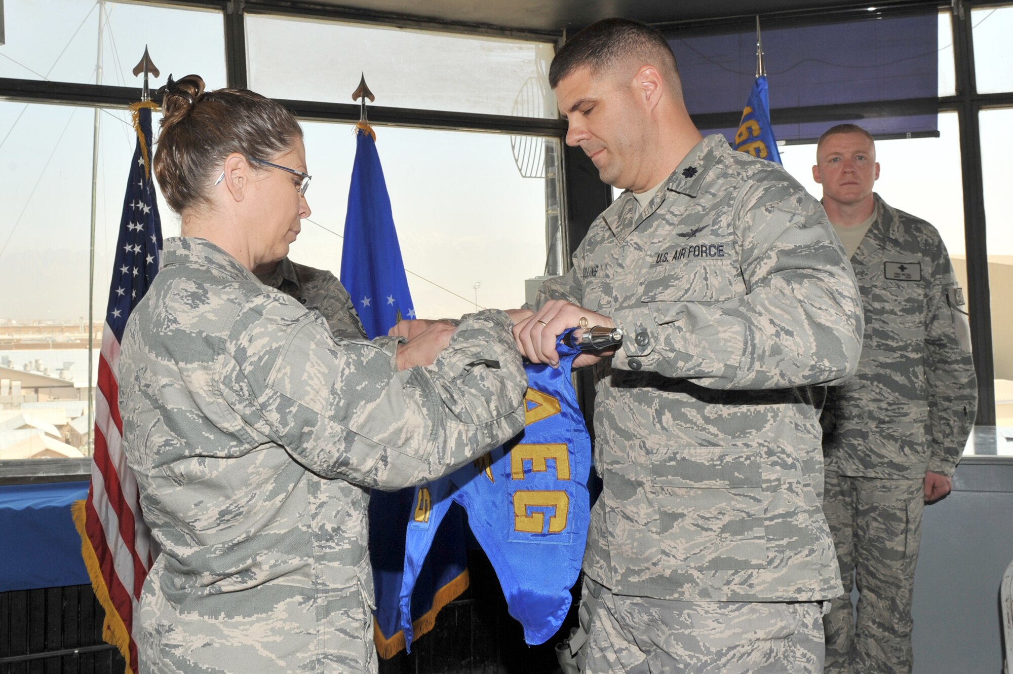 Col. Lesa Toler, 466th Air Expeditionary Group commander, and Lt. Col. Jeffrey Collins, 766th  Air Expeditionary Squadron commander, rolls the guidon as Lt. Col. Collins relinquishes command during the 766th AES inactivation ceremony at Bagram Airfield, Afghanistan, March 23, 2011. Colonel Collins will assume command of the 966th Air Expeditionary Squadron. (U.S. Air Force photo by Senior Airman Sheila deVera)