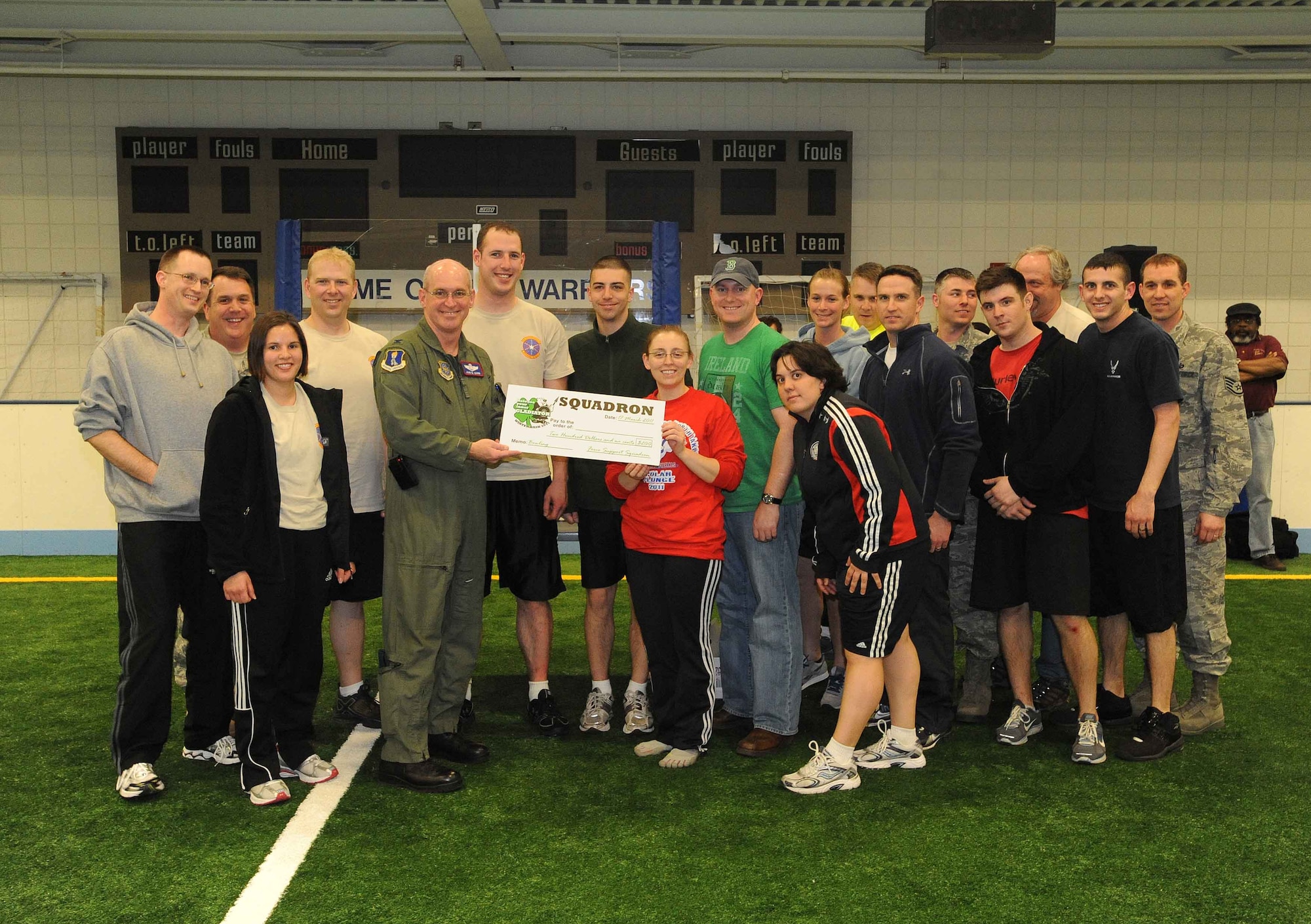 Col. John Quinn, 319th Air Base Wing vice wing commander, presents members of the 319th Operations Support Squadron with the third-place award Mar. 17 at the base fitness center following the conclusion of the 2011 Grand Forks Air Force Base Winter Bash. (U.S. Air Force photo by Tech. Sgt. Johnny Saldivar)