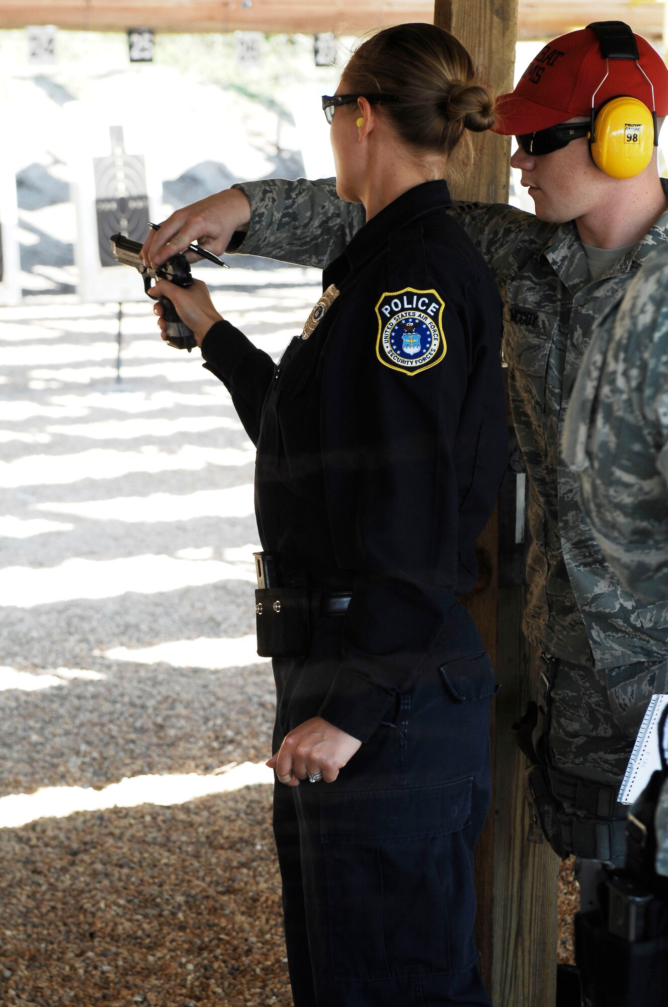 Senior Airman Patrick McCoy, 633d Security Forces squadron combat arms training and maintenance instructor, helps Renee Stoner, 733d SFS, operations sergeant, during a marksmanship competition at Langley Air Force Base, Va., March 18, 2011.  Security forces members participated in the first annual event to build cohesiveness between Joint Base Langley-Eustis military police. (U.S. Air Force photo by Airman 1st Class Kayla Newman/Released)