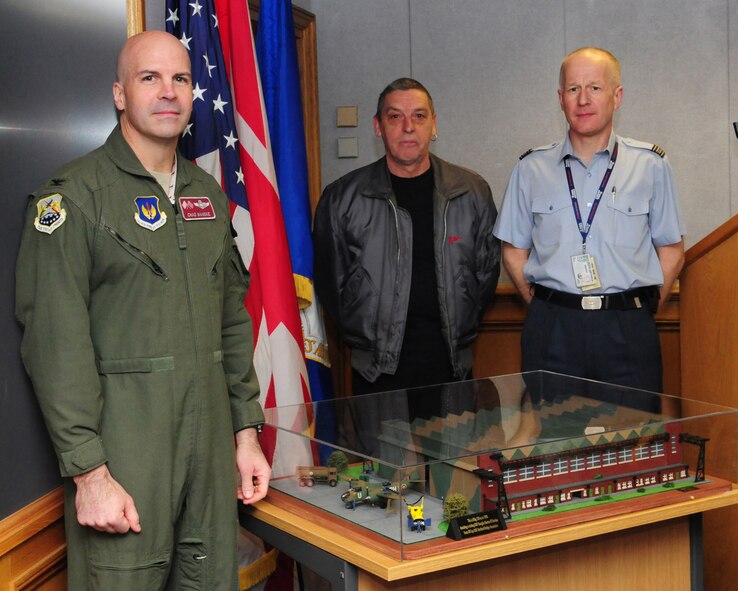 RAF MILDENHALL, England -- Col. Chad Manaske, 100th Air Refueling Wing commander, Ray Rowson, 100th Civil Engineer Squadron, and Sqadron Leader Rick Fryer, RAF Mildenhall Station Commander, pose by the model of Building 550 recently built by Mr. Rowson. The model is a replica of one of the three original historical hangars at RAF Mildenhall as it appeared in 1943. He has donated the model to the base, and it is currently on display upstairs at the Galaxy Club. (U.S. Air Force photo/Karen Abeyasekere)