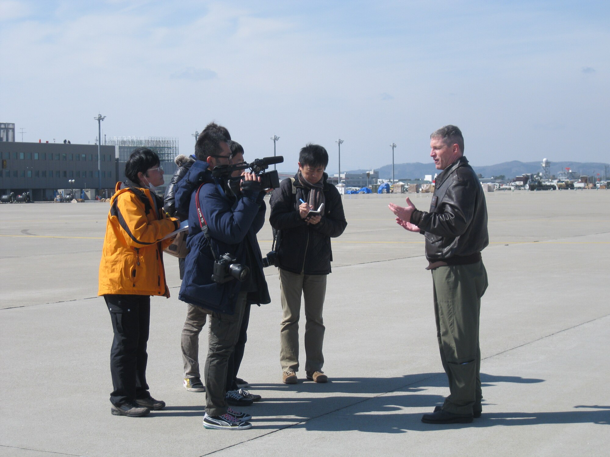 SENDAI, Japan-- Japanese media representatives interview Maj. Rob Mitchell, 36th Airlift Squadron pilot at Yokota Air Base, after a flight to Sendai Airport March 24, 2011. The 36th AS delivered 2,378 gallons of diesel fuel aboard a C-130H Hercules at the request of the government of Japan.
