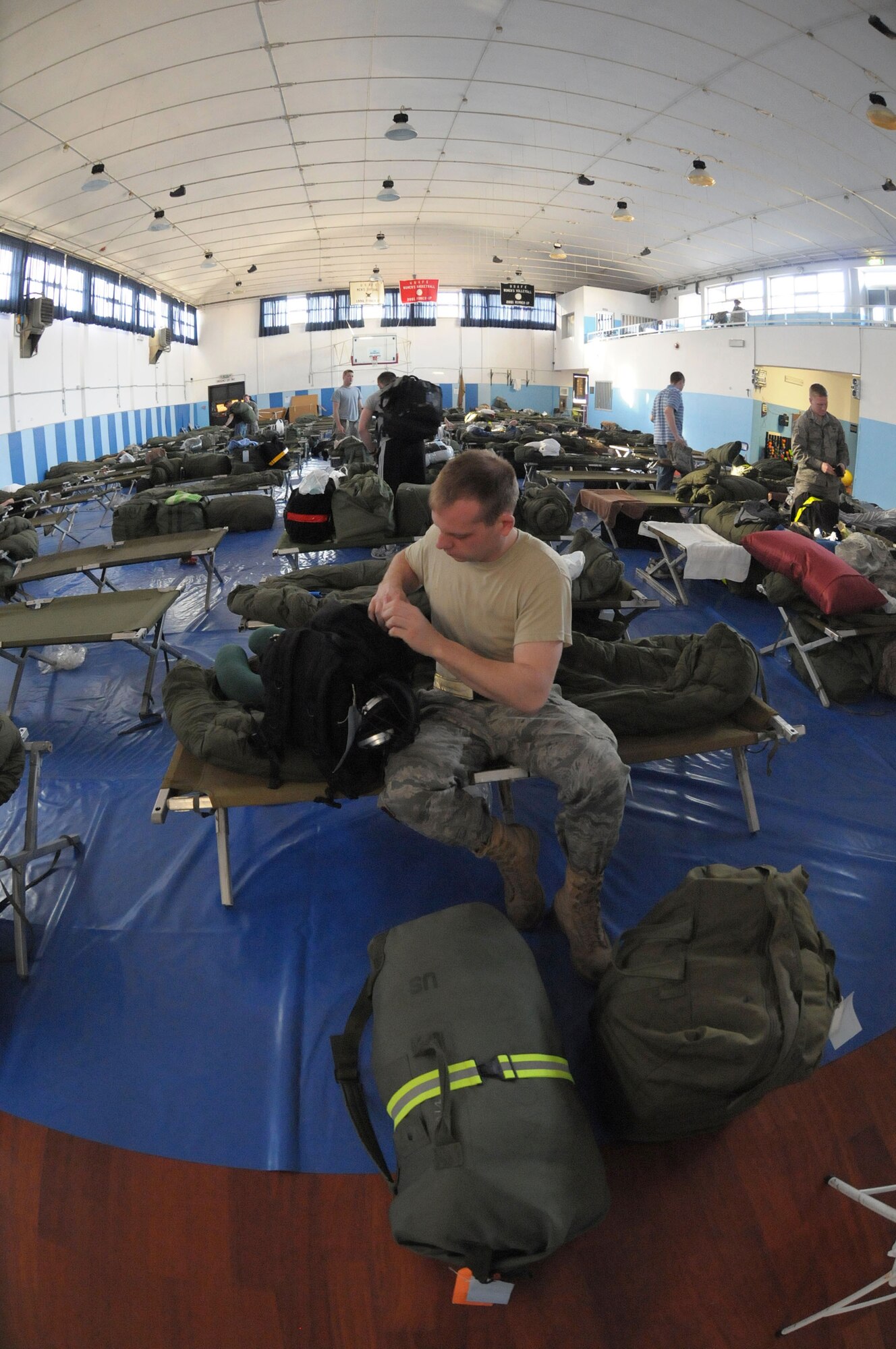 An Airman prepares for work while in temporary quarters at Falcon Fitness Center, Aviano Air Force Base, Italy, March 22, 2011. Joint Task Force Odyssey Dawn is the U.S. Africa Command Task force established to support the larger international response to the unrest in Libya. A broad coalition of nations are partnering to enforce U.N. Security Council Resolution (UNSCR) 1973, which authorizes all necessary means to protect civilians in Libya under threat of attack by Qadhafi regime forces.  JTF Odyssey Dawn is commanded by Admiral Samuel J. Locklear, III.  (US Army Photo by SSG Tierney P. Wilson) 