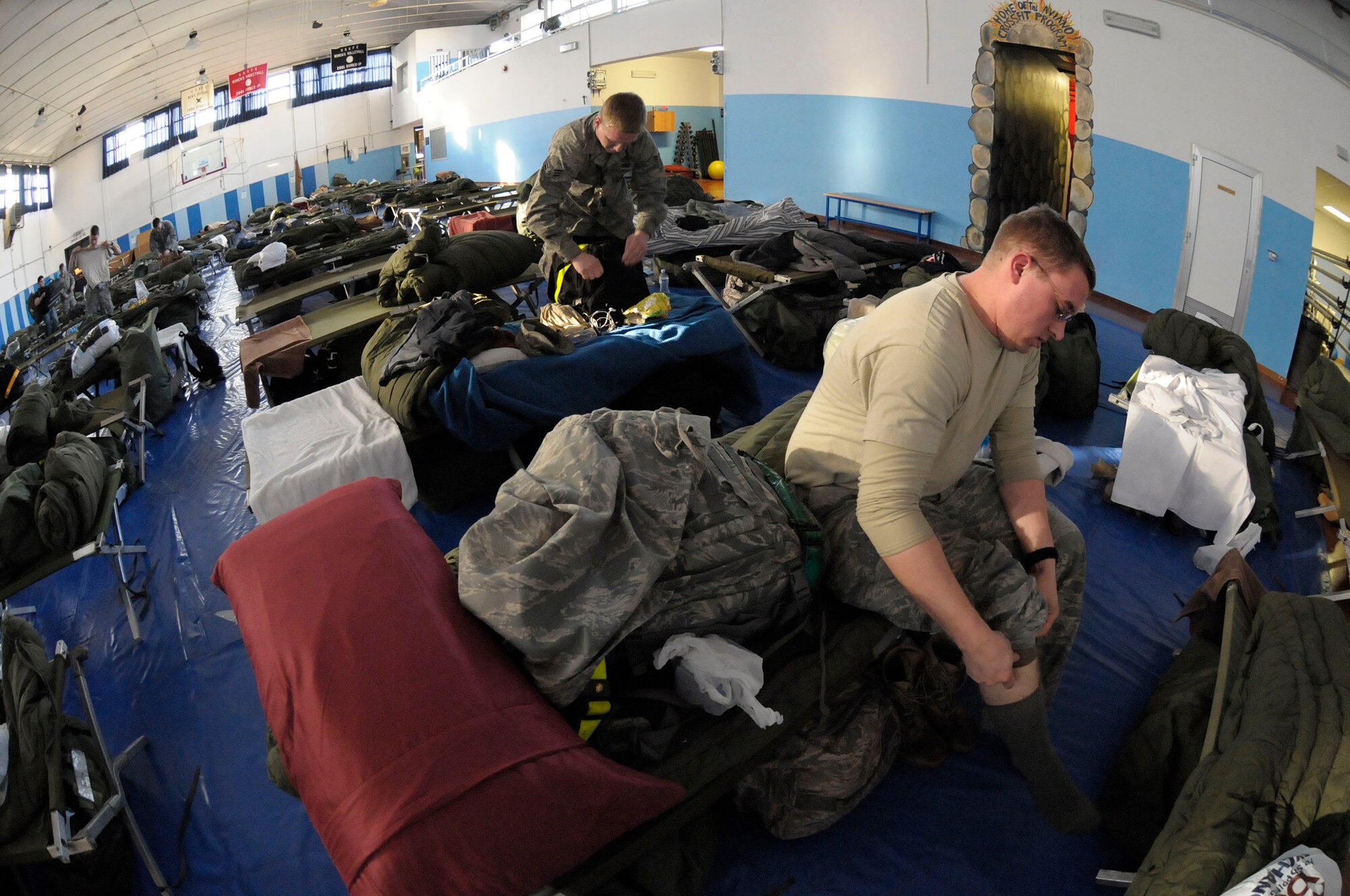 An Airman prepares for work while in temporary quarters at Falcon Fitness Center, Aviano Air Force Base, Italy, March 22, 2011. Joint Task Force Odyssey Dawn is the U.S. Africa Command Task force established to support the larger international response to the unrest in Libya. A broad coalition of nations are partnering to enforce U.N. Security Council Resolution (UNSCR) 1973, which authorizes all necessary means to protect civilians in Libya under threat of attack by Qadhafi regime forces.  JTF Odyssey Dawn is commanded by Admiral Samuel J. Locklear, III.  (US Army Photo by SSG Tierney P. Wilson)