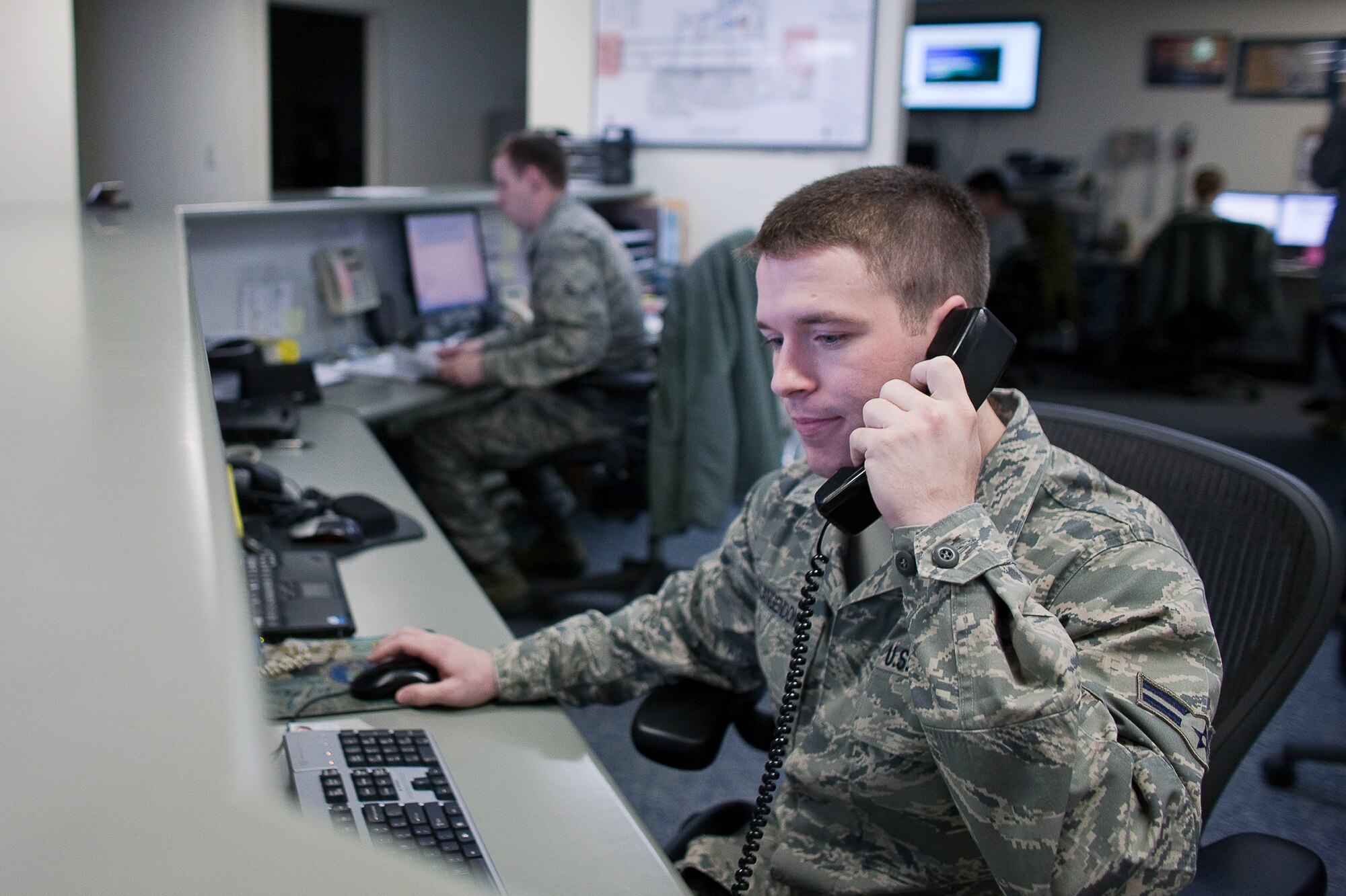 YOKOTA AIR BASE, Japan -- Airman 1st Class Andrew Vanlangendonck, 374th Operations Support Squadron, responds to a question about an up-coming flight at Yokota Air base, Japan, March 24. A native of Williston, Florida, Airman Vanlangendonck files flight plans, performs airfield inspections, and provides general support to aircrew members. Along with his fellow Airmen, he has been working 12-hour shifts in support of Operation Tomodachi.  (U.S. Air Force photo/Osakabe Yasuo)