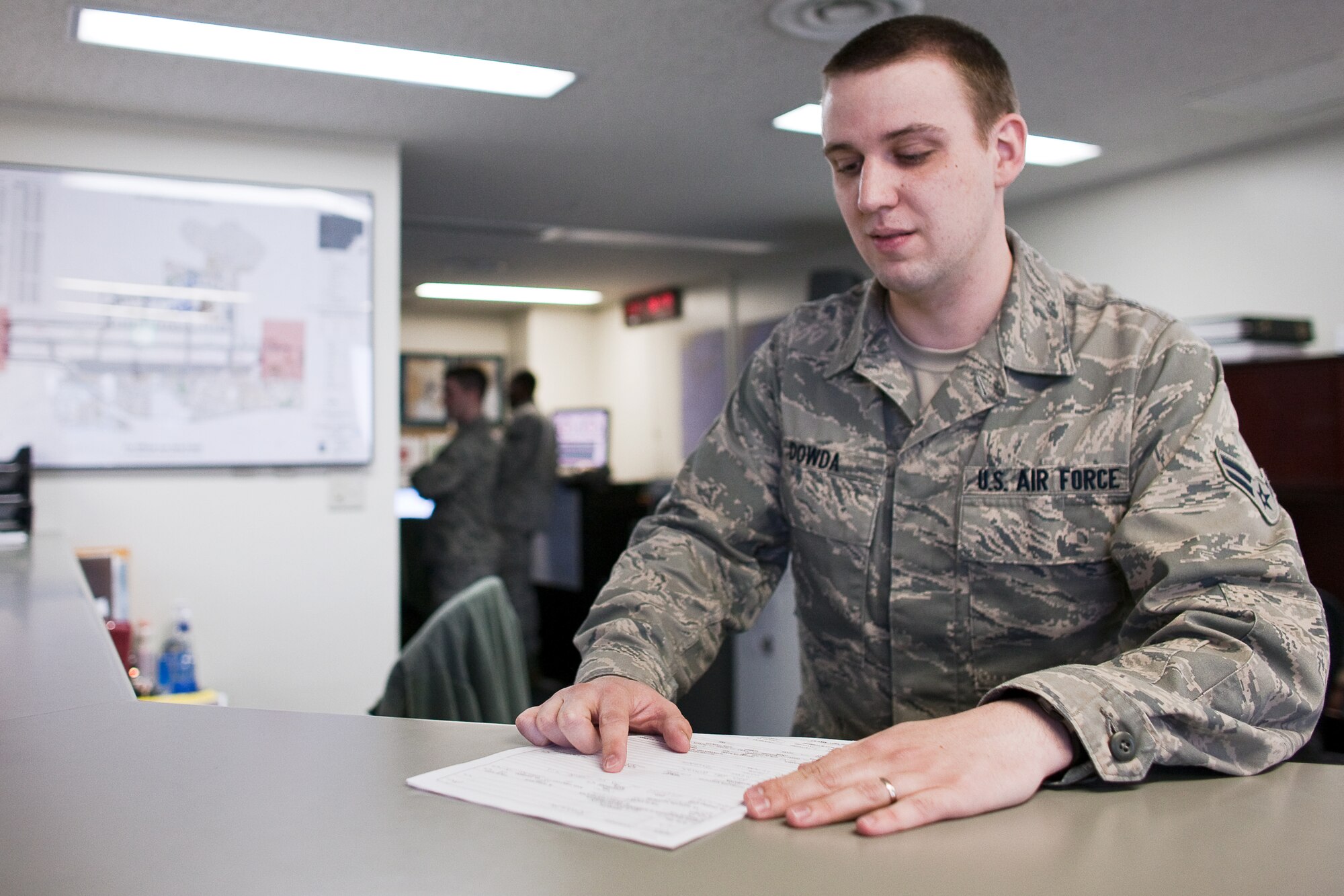 YOKOTA AIR BASE, Japan -- Airman 1st Class Laurence Dowda, 374th Operations Support Squadron, inspects a flight plan before briefing a pilot at Yokota Air base, Japan, March 24. A native of Kingsport, Tennessee, Airman Dowda files flight plans, performs airfield inspections, and provides general support to aircrew members. Along with his fellow Airmen, he has been working 12-hour shifts in support of Operation Tomodachi.  (U.S. Air Force photo/Osakabe Yasuo)