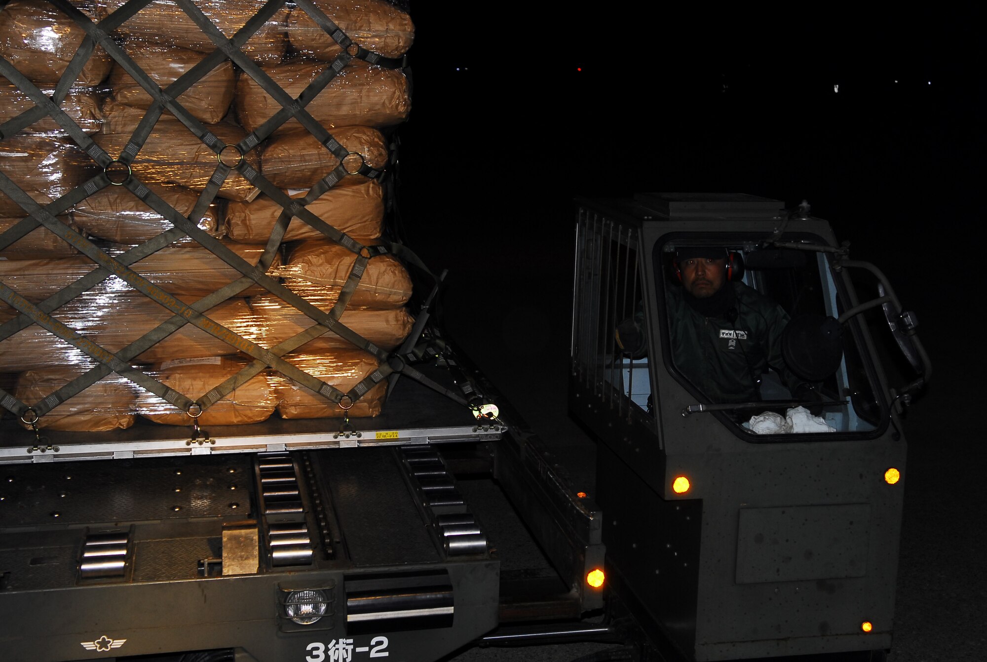 MATSUSHIMA, Japan -- A Japanese worker in Matsushima, Japan, drives a k-loader carrying a pallet with humanitarian relief supplies March 23. Members from the 36th Airlift Squadron from Yokota Air Base, Japan, transported 15,000 pounds worth of blankets, water and rice from Chitose Air Base, Japan, to Matsushima, Japan. (U.S. Air Force photo/Staff Sgt. Robin Stanchak)