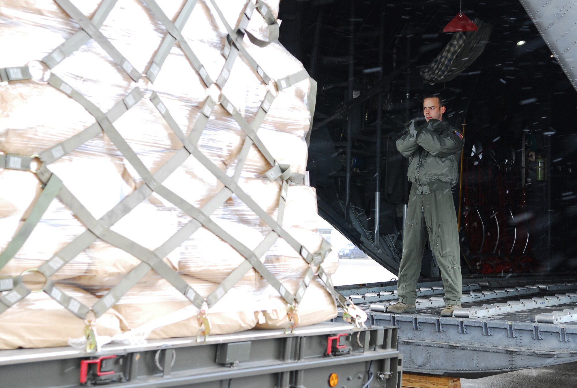 CHITOSE AIR BASE, Japan -- Senior Airman Brandon Lee, 36th Airlift Squadron C-130 Hercules loadmaster, from Yokota Air Base, Japan, guides a pallet with humanitarian relief supplies onto the aircraft at Chitose Air Base, Japan, March 23. The aircraft transported six pallets carrying 15,000 pounds of blankets, water and rice from the air base to Matsushima, Japan. (U.S. Air Force photo/Staff Sgt. Robin Stanchak)