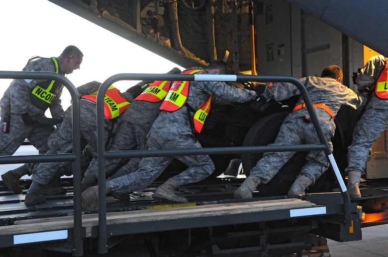 SPANGDAHLEM AIR BASE, Germany – Airmen from the 52nd Logistics Readiness Squadron push cargo into a C-130J Super Hercules here in support of Operation Odyssey Dawn March 21. Joint Task Force Odyssey Dawn is the U.S. Africa Command task force established to provide operational and tactical command and control of U.S. military forces supporting the international response to the unrest in Libya and enforcement of United Nations Security Council Resolution (UNSCR) 1973. UNSCR 1973 authorizes all necessary measures to protect civilians in Libya under threat of attack by Qadhafi regime forces.  JTF Odyssey Dawn is commanded by U.S. Navy Admiral Samuel J. Locklear, III. (U.S. Air Force photo/Airman 1st Class Matthew B. Fredericks)