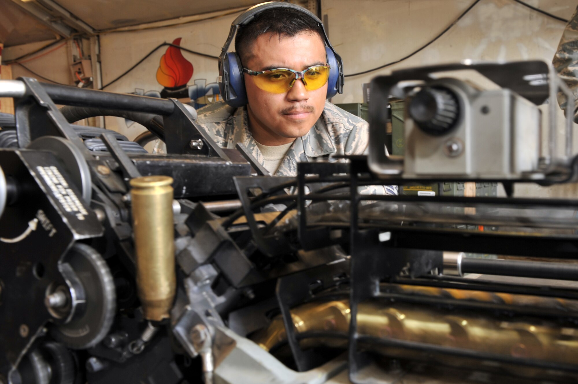Staff Sgt. Raul Vierness, 455th Expeditionary Maintenance Squadron Ammunition Supply Point technician, watch 20 millimeter round cycles through the linkless ammunition loading system at Bagram Airfield, Afghanistan, March 23, 2011. Once the round has gone through the LAL system, they can be inspected. Sergeant Vierness is deployed from Mountain Home Air Force Base, Idaho. (U.S. Air Force photo by Senior Airman Sheila deVera)
