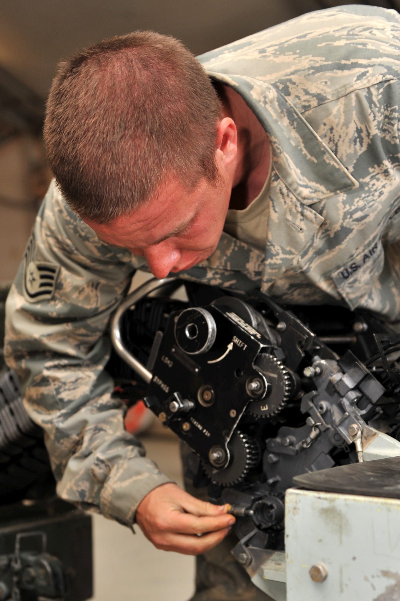 Staff Sgt. Glen Vart, 455th Expeditionary Maintenance Squadron Ammunition Supply Point technician, connects the linkless ammunition loading system to the replenisher table at Bagram Airfield, Afghanistan, March 23, 2011. The loading system allows cycling of 20 millimeter rounds for inventory and inspection.  Sergeant Vart is deployed from Hill Air Force Base, Utah. (U.S. Air Force photo by Senior Airman Sheila deVera)