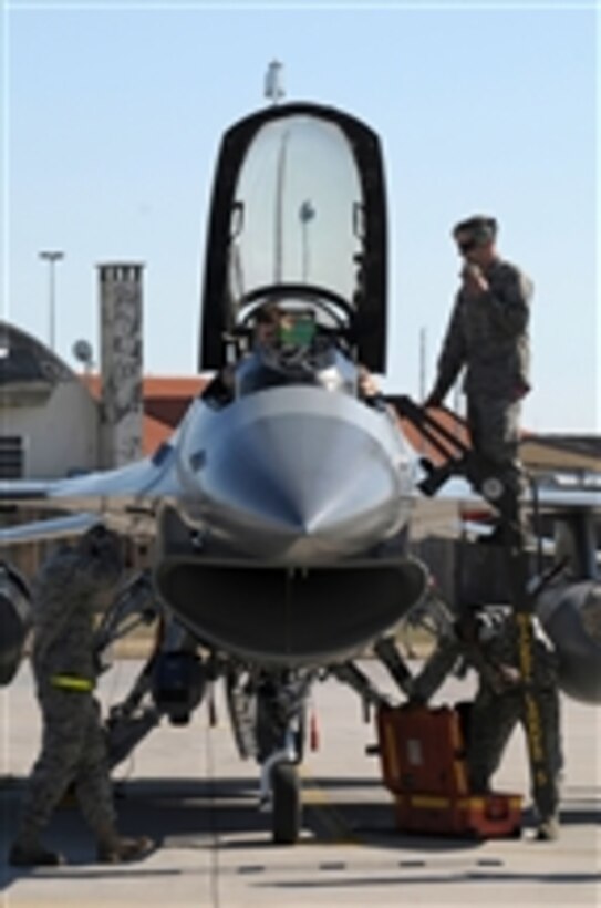 U.S. Air Force F-16 Fighting Falcon flight crew members perform post-flight checks at Aviano Air Force Base, Italy, after the F-16 pilot returns from supporting Joint Task Force Odyssey Dawn on March 20, 2011.  Joint Task Force Odyssey Dawn is the U.S. Africa Command task force established to support the larger international response to the unrest in Libya.  