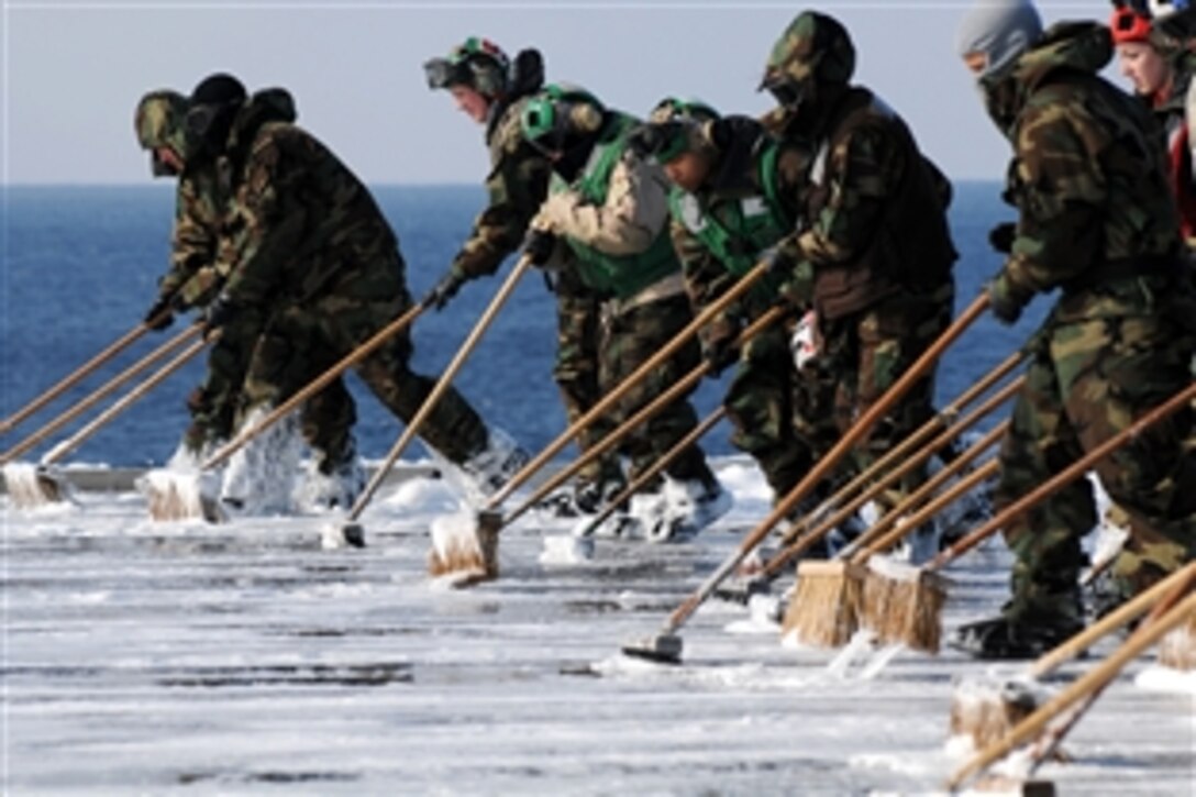 U.S. Navy sailors scrub the flight deck aboard the aircraft carrier USS Ronald Reagan following a countermeasure wash down to decontaminate the flight deck while the ship is operating off the coast of Japan in the Pacific Ocean, March 23, 2011. Sailors scrubbed the external surfaces on the flight deck and island superstructure to remove potential radiation contamination. Ronald Reagan is operating off the coast of Japan providing humanitarian assistance.