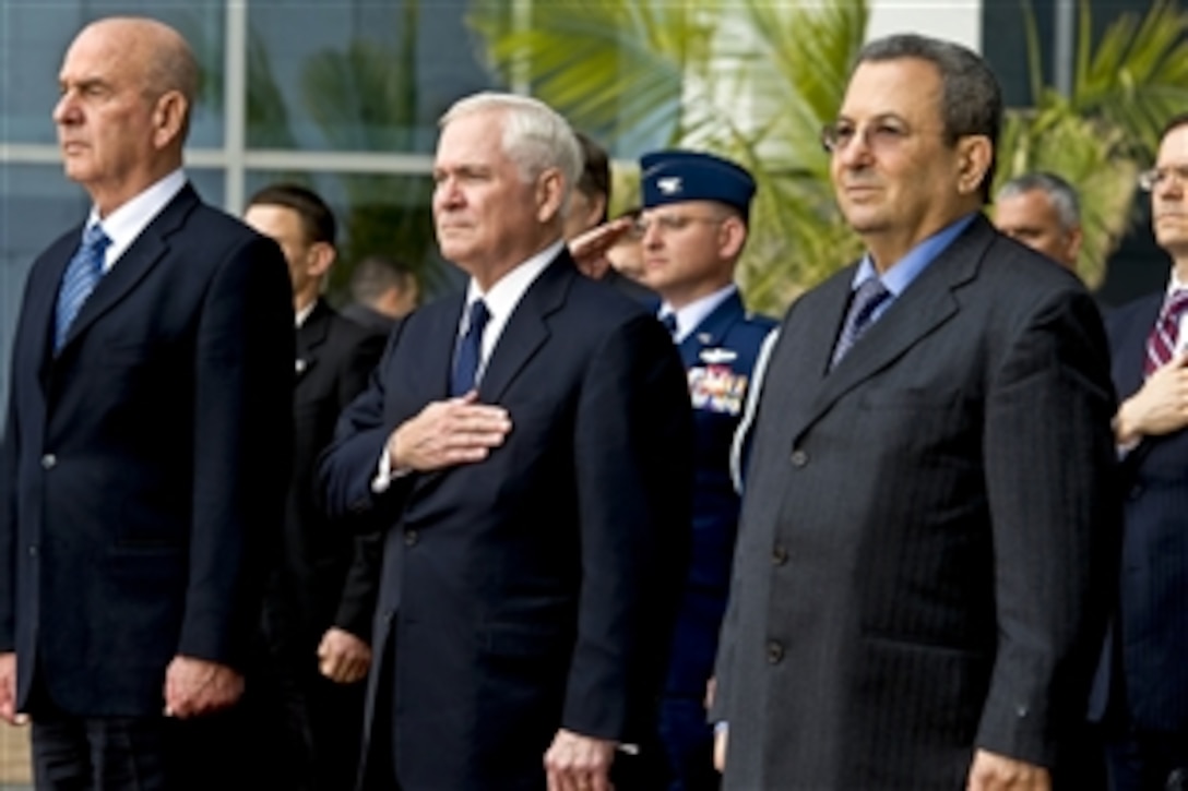 U.S. Defense Secretary Robert M. Gates, center, Israeli Defense Minister Ehud Barak, right, and their staff members render honors during the playing of the national anthem during an arrival ceremony in Tel Aviv, Israel, March 24, 2011.