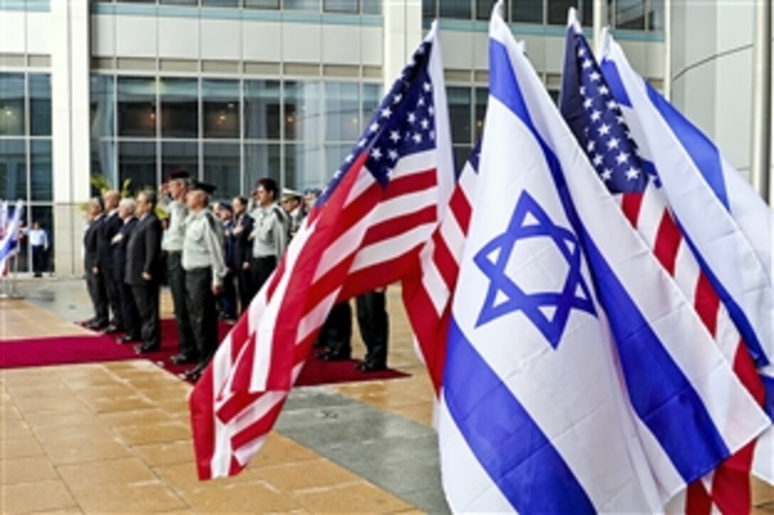 U.S. Defense Secretary Robert M. Gates, Israeli Defense Minister Ehud Barak and their staff members render honors during the playing of the national anthem during an arrival ceremony in Tel Aviv, Israel, March 24, 2011.