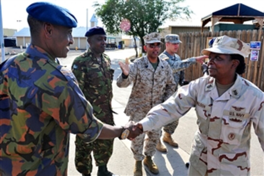 Kenyan Defense Force Sgt. Maj. Khanso, left, is greets Camp Lemonnier U.S. Navy Command Master Chief Rosa Wilson, in Djibouti during a command orientation tour, March 14, 2011. The Kenyan delegation visited to partner with American non-commissioned officers to exchange best practices on mentoring enlisted personnel.