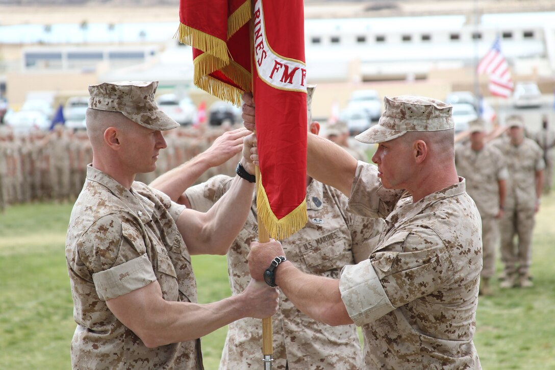 Lieutenant Col. Seth Folsom [left], the new commanding officer for 3rd Battalion, 7th Marine Regiment, accepts the unit’s colors from Lt. Col. Clay Tipton, the outgoing commander, during a change of command ceremony at Lance Cpl. Torrey L. Gray Field March 25, 2011.::r::::n::