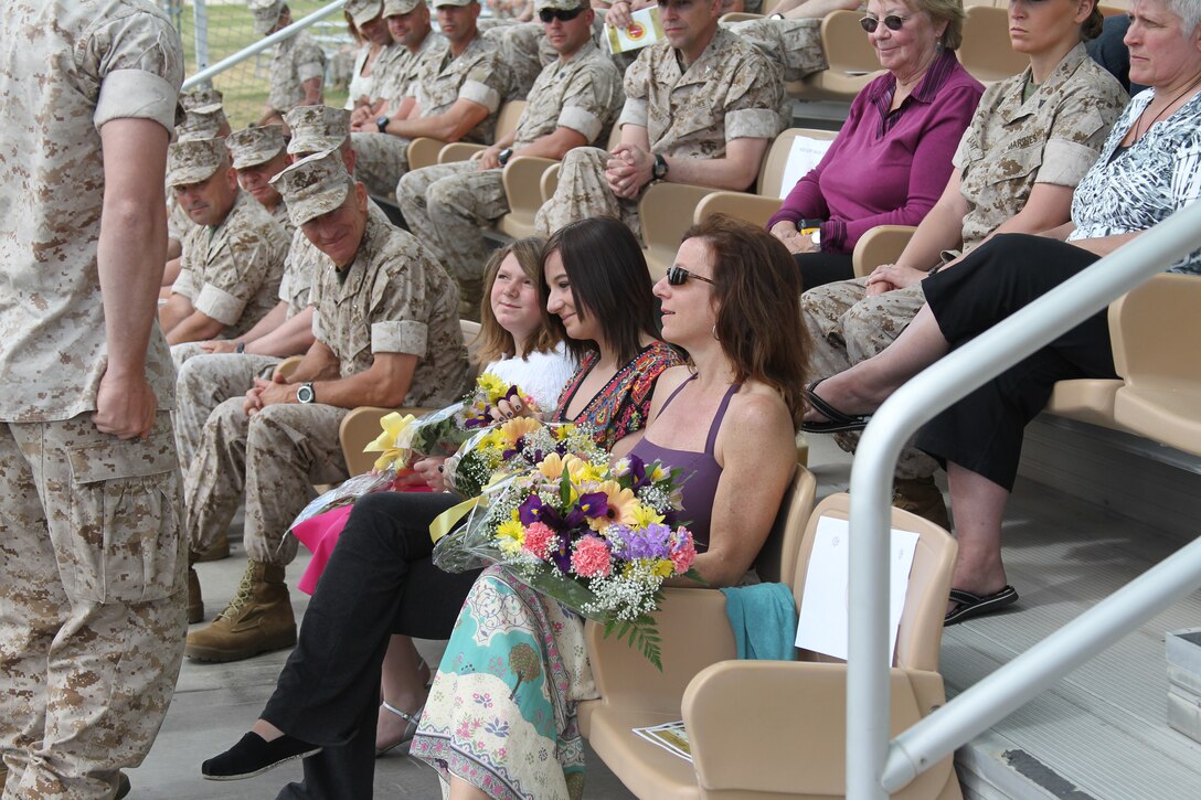 Julie Tipton, wife of Lt. Col. Clay Tipton, and their daughters, Bailey, age 14 and Riley, age 11, hold flowers they received during the 3rd Battalion, 7th Marine Regiment change of command ceremony March 25, 2011. Tipton relinquished command of the “Cutting Edge,” as the unit is called, to Lt. Col. Seth Folsom.::r::::n::