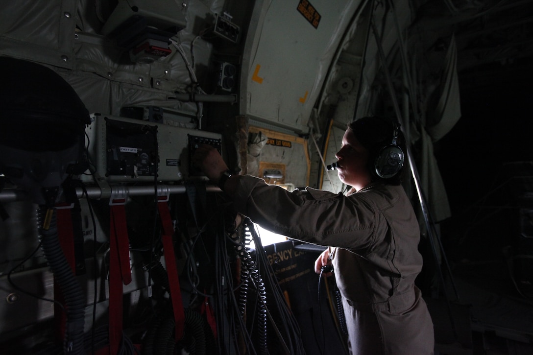 Cpl. Jessica M. Egan, a crew chief with Marine Aerial Refueler Transport Squadron 352, adjusts the communication system on the Harvest Hawk equipped KC-130J after taking off from Camp Dwyer, Afghanistan, march 25. The one-of-a-kind Harvest Hawk system includes a version of the target sight sensor used on the AH-1Z Cobra attack helicopter as well as a complement of four AGM-114 Hellfire and 10 Griffin missiles. This unique variant of the KC-130J supports 2nd Marine Aircraft Wing (Forward) in providing closer air support and surveillance for coalition troops on the ground in southwestern Afghanistan.