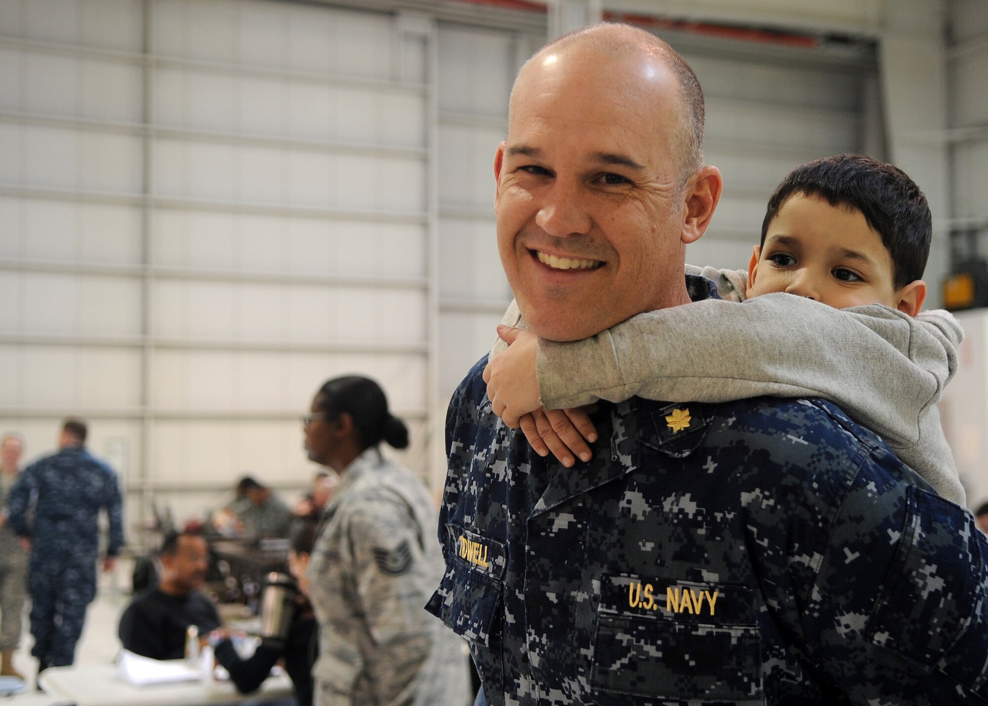 Buckley Air Force Base, Colo- Lt. Commander Chad Tidwell, United States Navy Reserve, gives Ethan Schinder a piggy back ride March 25, 2011. Denver International Airport has been receiving military dependent evacuees from Japan during Operation Pacific Passage. Lt. Commander Tidwell volunteered to welcome home the evacuees and to entertain some of the children awaiting their next destination. (U.S. Air Force photo by Airman 1st Class Marcy Glass)