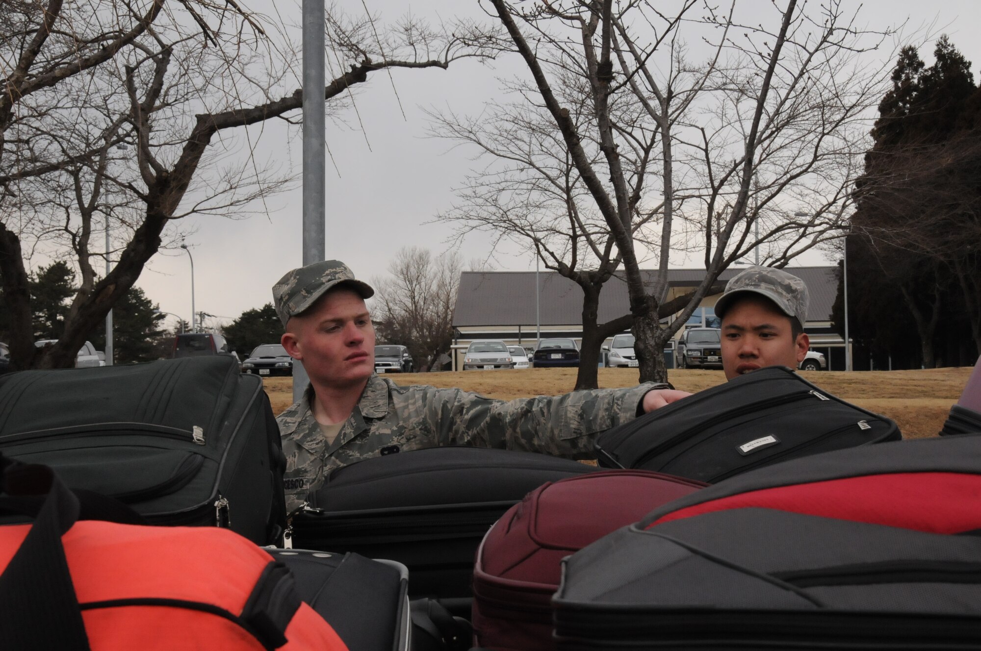 MISAWA AIR BASE, Japan -- Airman 1st Class Christian DeFrancesco and Senior Airman Duc Nguyen, both assigned to the 35th Logistics Readiness Squadron, count passenger bags belonging to families voluntarily departing Misawa March 24. Airman DeFrancesco is from Meadville, Penn. Airman Nguyen is from Littleton, Colo. (U.S. Air Force photo by Staff Sgt. Rachel Martinez/Released)