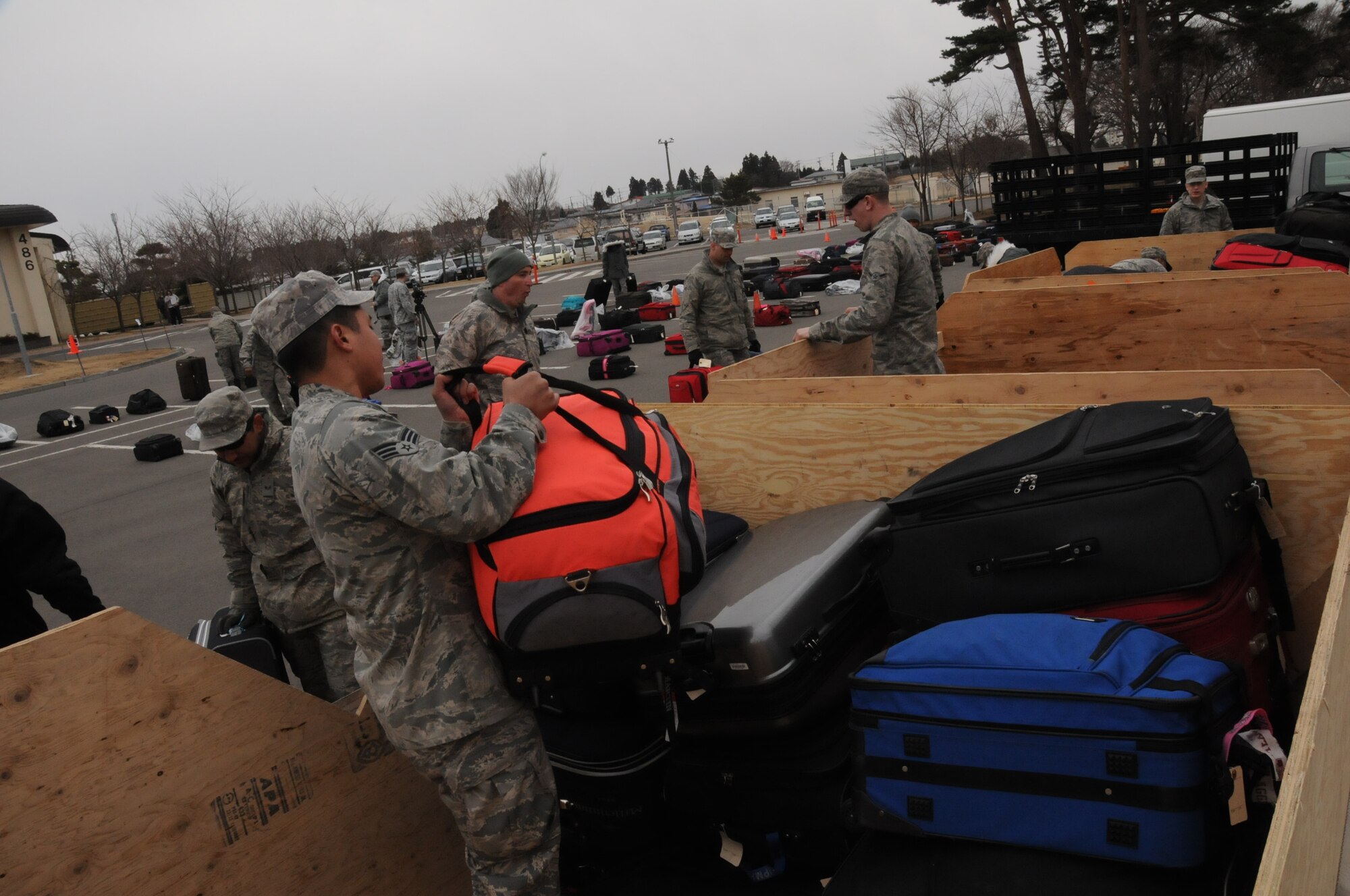 MISAWA AIR BASE, Japan -- Airmen from the 35th Logistics Readiness Squadron load passenger bags into cargo bins outside the collocated club March 24. The Airmen played a large role in the voluntary departure process for Misawa families. (U.S. Air Force photo by Staff Sgt. Rachel Martinez/Released)