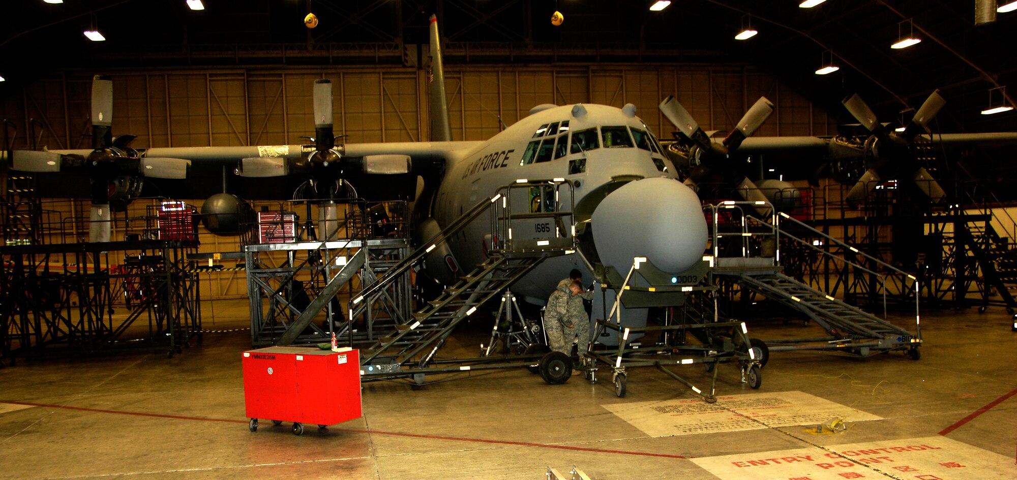 YOKOTA AIR BASE, Japan -- Airman 1st Class Travis Farr (left) and Staff Sgt. Alex Montero carry a C-130 Hercules forward landing gear door to a storage rack March 25, 2011. Removing the door helps electricians complete necessary repairs easier. The C-130 is undergoing routine maintenace in preparation to support Operation Tomodachi. Both Airmen are crew chiefs with the 374th Maintenance Squadron. (U.S. Air Force photo/ Staff Sgt. J.G. Buzanowski)