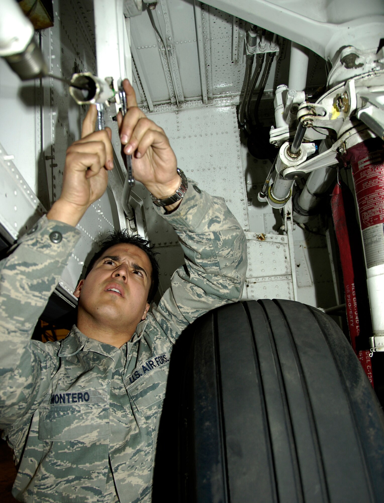 YOKOTA AIR BASE, Japan -- Staff Sgt. Alex Montero removes a C-130 Hercules forward landing gear door March 25, 2011. Removing the door helps electricians complete necessary repairs easier. The C-130 is undergoing routine maintenace in preparation to support Operation Tomodachi. Sergeant Montero is a crew chief with the 374th Maintenance Squadron. (U.S. Air Force photo/ Staff Sgt. J.G. Buzanowski)