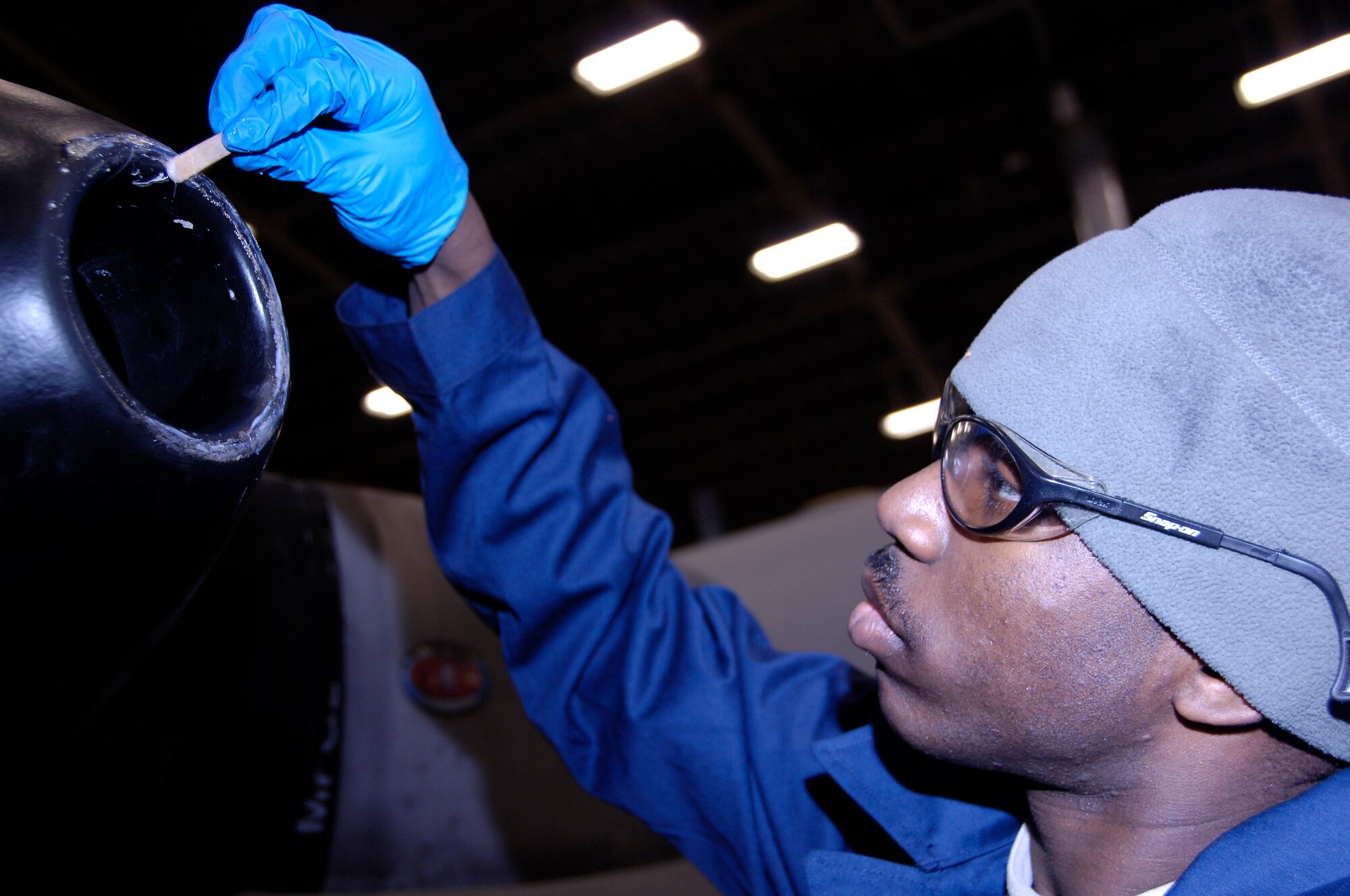 YOKOTA AIR BASE, Japan -- Airman 1st Class Jared Hunt applies an epoxy compound to the spinner on a C-130 Hercules engine March 25,2011. The compound fills in pits and cracks extending the service life of the aircraft. The C-130 is undergoing routine maintenace in preparation to support Operation Tomodachi. Airman Hunt is an aerospace propulsion journeyman with the 374th Maintenance Squadron. (U.S. Air Force photo/ Staff Sgt. J.G. Buzanowski)