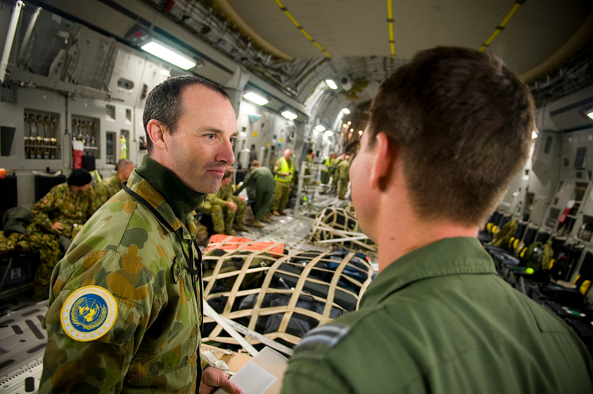 YOKOTA AIR BASE, Japan -- Royal Australian Air Force Maj. Michael Haldow, assistant defense attache, speaks with one of the loadmasters on a Royal Australian Air Force C-17 Globemaster III flying back to Australia here March. 25. The RAAF was here to assist the Japanese in relief efforts as a part of Operation Tomodachi. (U.S. Air Force photo/Staff Sgt. Chad C. Strohmeyer)