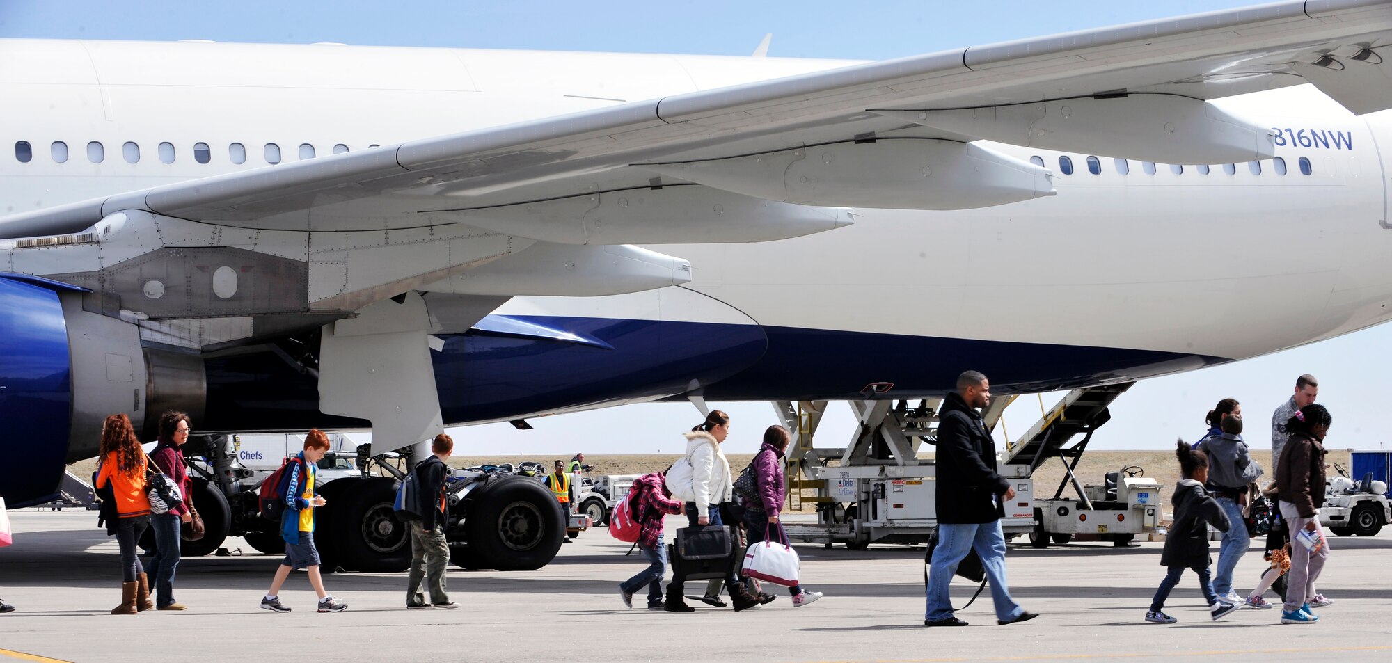 Military family members arriving from Japan exit an aircraft March 24, 2011, at Denver International Airport, Colo. Family members voluntarily evacuated from Japan due to the recent natural disaster. (U.S. Air Force photo/Airman 1st Class Paul Labbe)