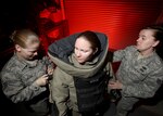 Staff Sgt. Diana Guinn (center) puts on an explosive ordnance disposal bomb suit with assistance from Staff Sgt. Molly Callen (left) and Staff Sgt. Nicole Nellist during a training exercise March 15. The sergeants are EOD technicians with the 802nd Civil Engineer Squadron. Lackland EOD is responsible for responding to explosives-related emergency calls in the southern half of Texas. (U.S. Air Force photo/Robbin Cresswell)