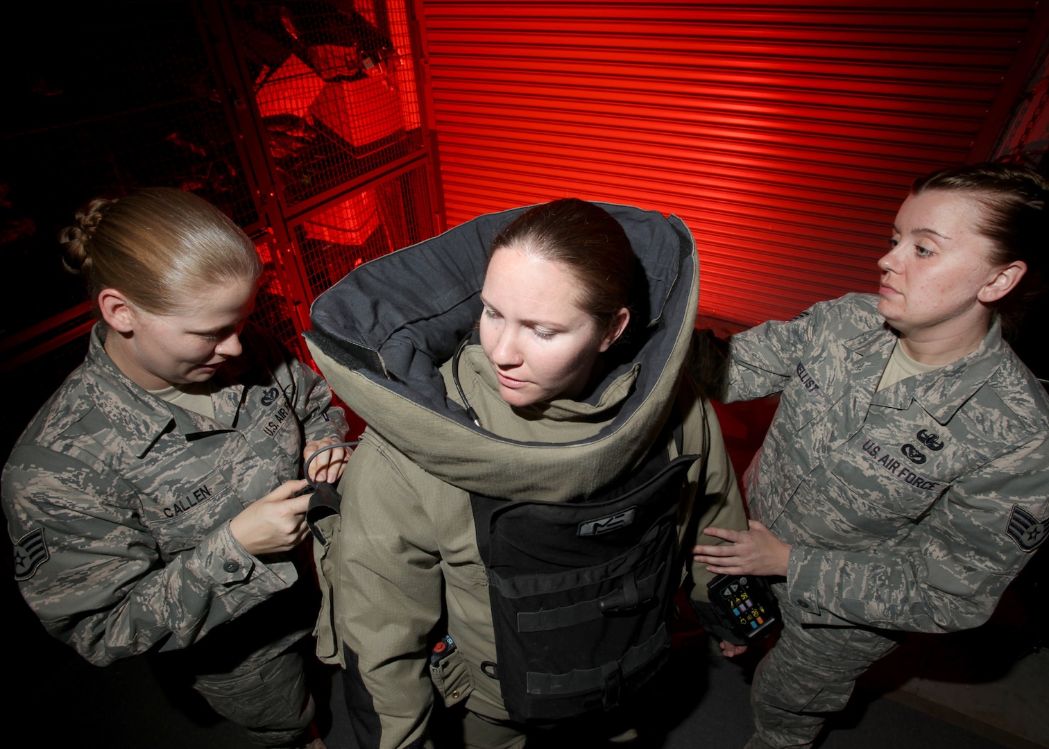 Staff Sgt. Diana Guinn (center) puts on an explosive ordnance disposal bomb suit with assistance from Staff Sgt. Molly Callen (left) and Staff Sgt. Nicole Nellist during a training exercise March 15. The sergeants are EOD technicians with the 802nd Civil Engineer Squadron. Lackland EOD is responsible for responding to explosives-related emergency calls in the southern half of Texas. (U.S. Air Force photo/Robbin Cresswell)
