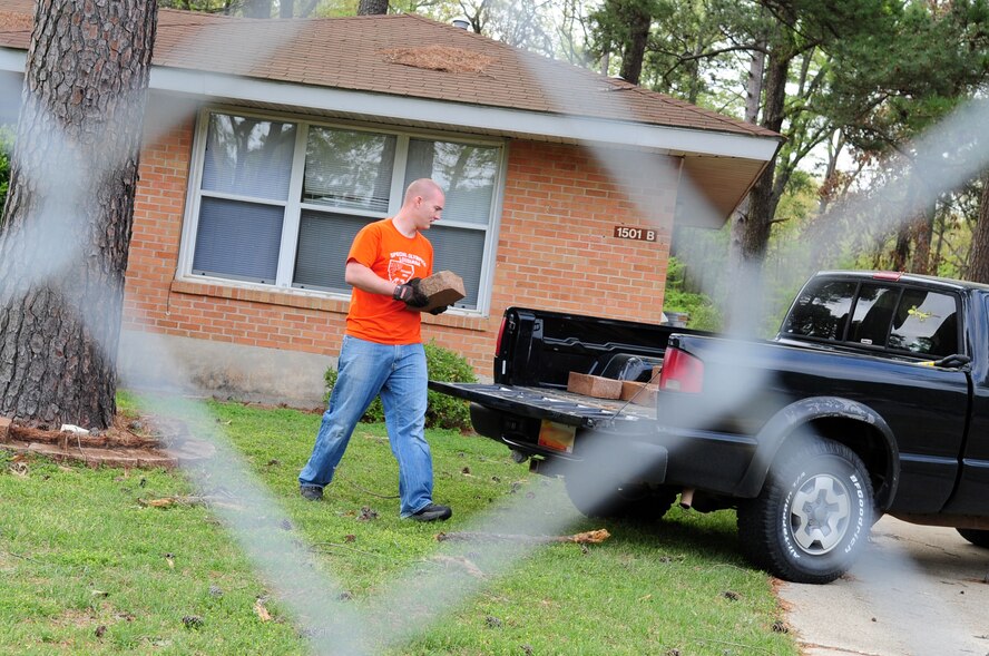 Senior Airman Brandon Briggs, 2nd Aircraft Maintenance Squadron, loads decorative lawn bricks into his vehicle from the lawn of a soon-to-be demolished Capehart Housing Area home on the East Side of Barksdale Air Force Base, La., March 25. The Capehart homes will be leveled and the area returned to nature. (U.S. Air Force photo/Senior Airman Joanna M. Kresge)