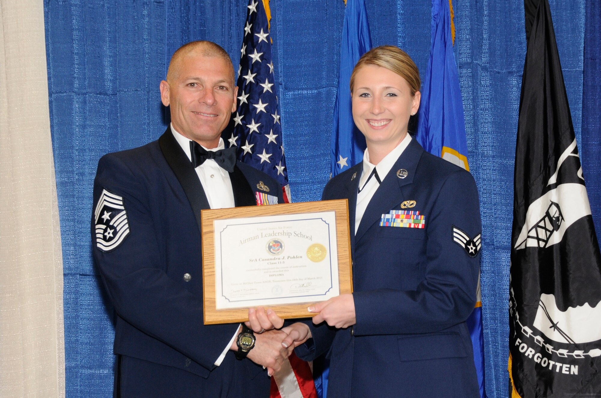 McGHEE TYSON AIR NATIONAL GUARD BASE, Tenn. - Senior Airman Casandra J. Pohlen, right, a civil engineer apprentice with the Minnesota Air National Guard, receives the distinguished graduate award for Airman Leadership School Class 11-3 at The I.G. Brown Air National Guard Training and Education Center from Louisiana Command Chief Master Sgt. James E. Downing, Sr., March 24, 2011.  The distinguished graduate award is presented to students in the top ten percent of the class.  It is based on objective and performance evaluations, demonstrated leadership, and performance as a team player. (U.S. Air Force photo by Master Sgt. Kurt Skoglund/Released)