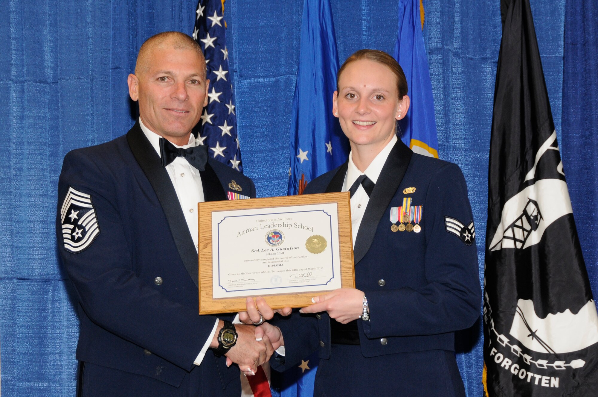 McGHEE TYSON AIR NATIONAL GUARD BASE, Tenn. - Senior Airman Lee A. Gustafson, right, a security forces journeyman with the Air Force Reserves, receives the distinguished graduate award for Airman Leadership School Class 11-3 at The I.G. Brown Air National Guard Training and Education Center from Louisiana Command Chief Master Sgt. James E. Downing, Sr., March 24, 2011.  The distinguished graduate award is presented to students in the top ten percent of the class.  It is based on objective and performance evaluations, demonstrated leadership, and performance as a team player. (U.S. Air Force photo by Master Sgt. Kurt Skoglund/Released)