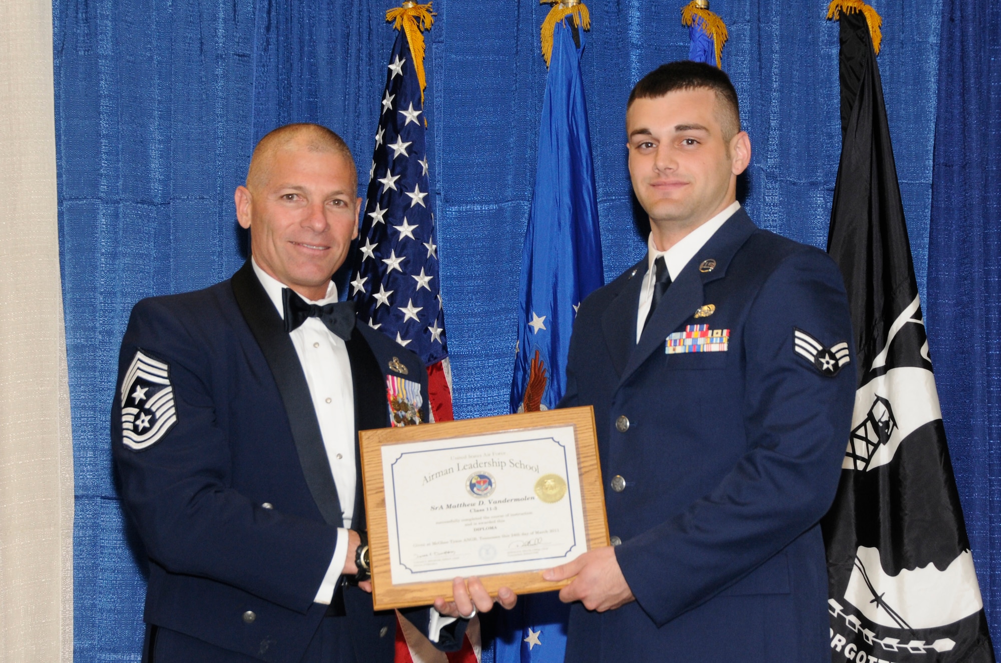 McGHEE TYSON AIR NATIONAL GUARD BASE, Tenn. - Senior Airman Matthew D. Vandermolen, right, a cyber systems operations journeyman with the Illinois Air National Guard, receives the distinguished graduate award for Airman Leadership School Class 11-3 at The I.G. Brown Air National Guard Training and Education Center from Louisiana Command Chief Master Sgt. James E. Downing, Sr., March 24, 2011.  The distinguished graduate award is presented to students in the top ten percent of the class.  It is based on objective and performance evaluations, demonstrated leadership, and performance as a team player. (U.S. Air Force photo by Master Sgt. Kurt Skoglund/Released)